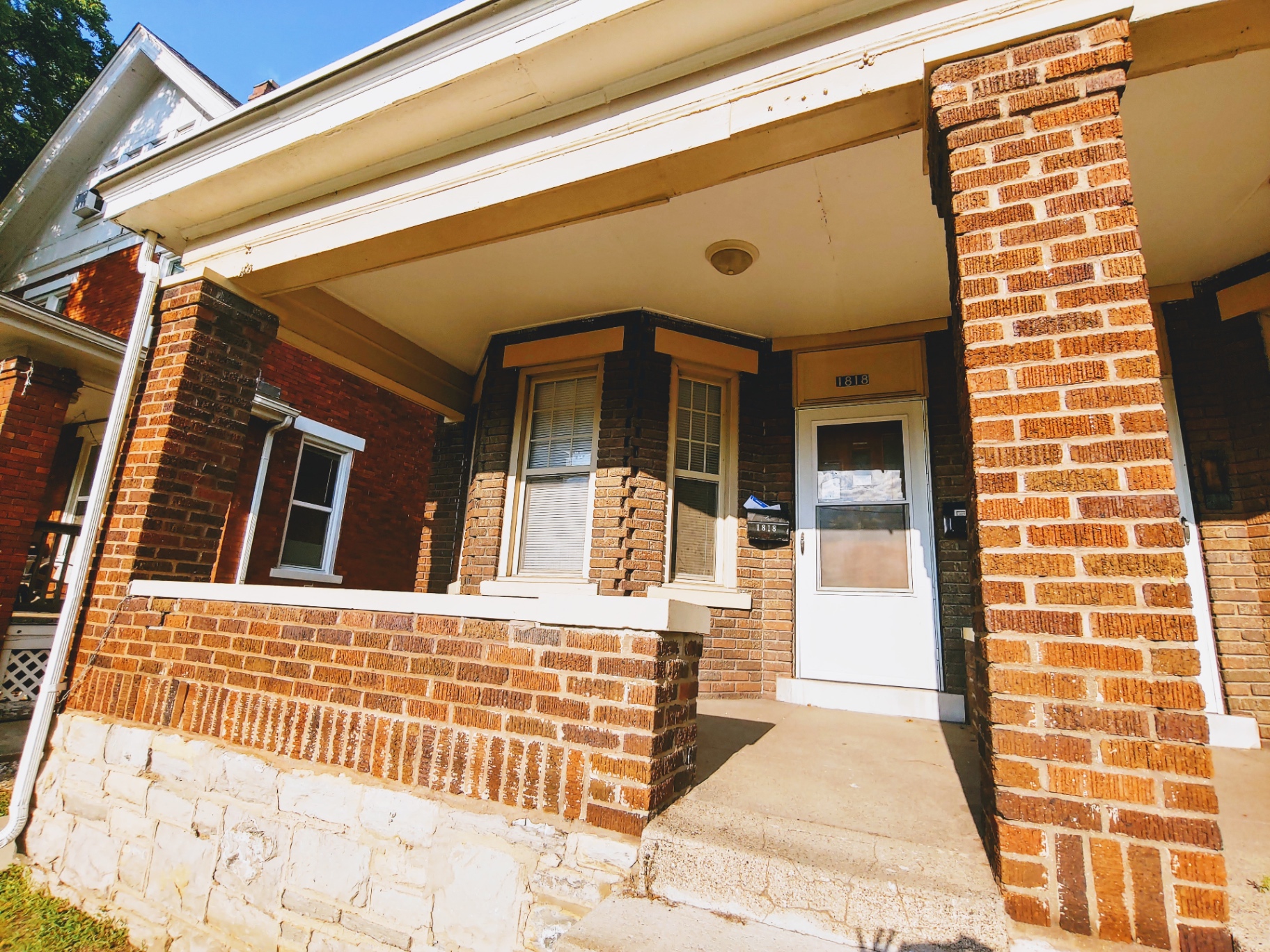 1818 Summit St. brick porch entry with bay window and address transom