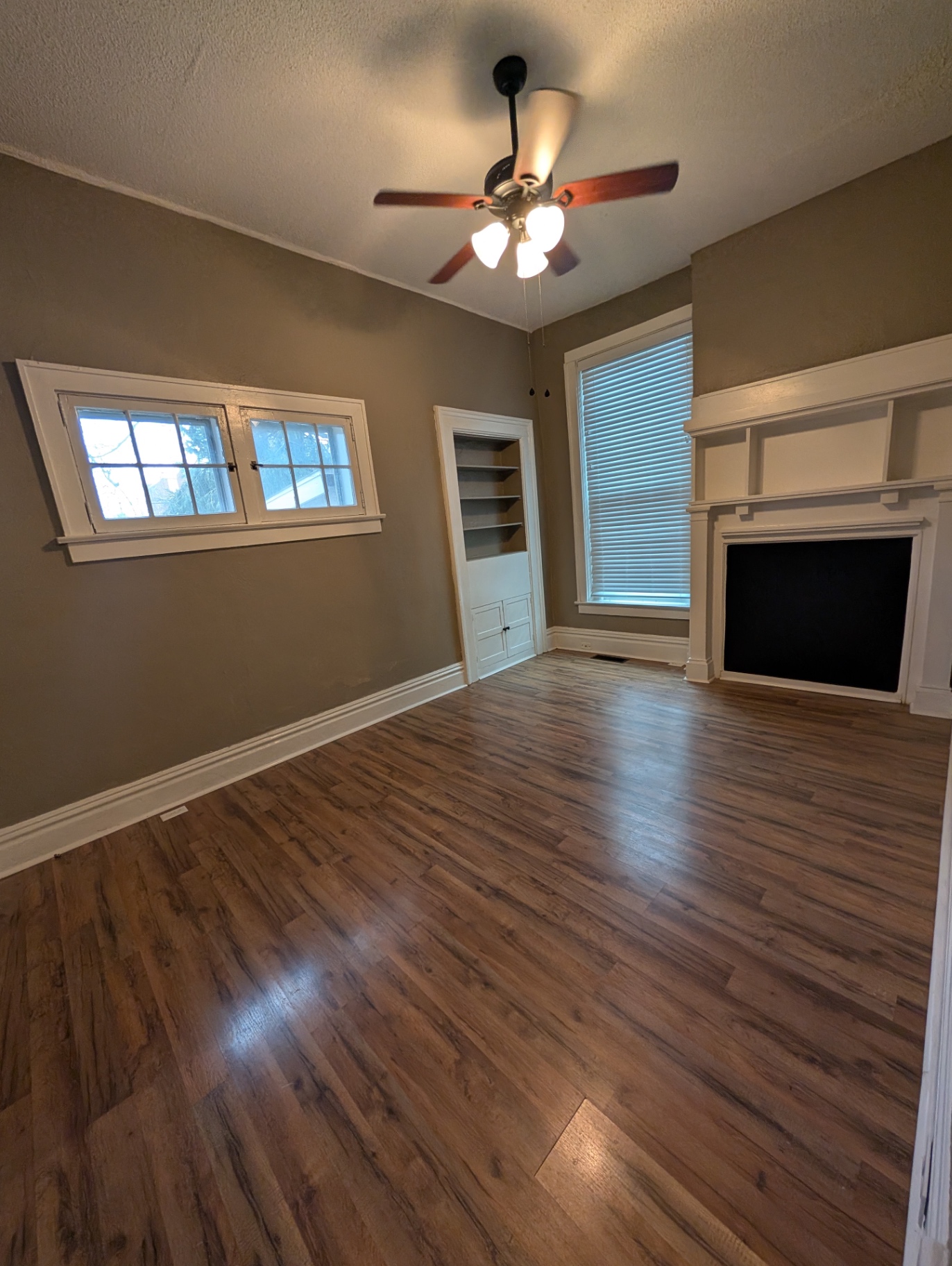 3338 Chestnut Downstairs living room with ceiling fan, built-in bookshelf and decorative mantel