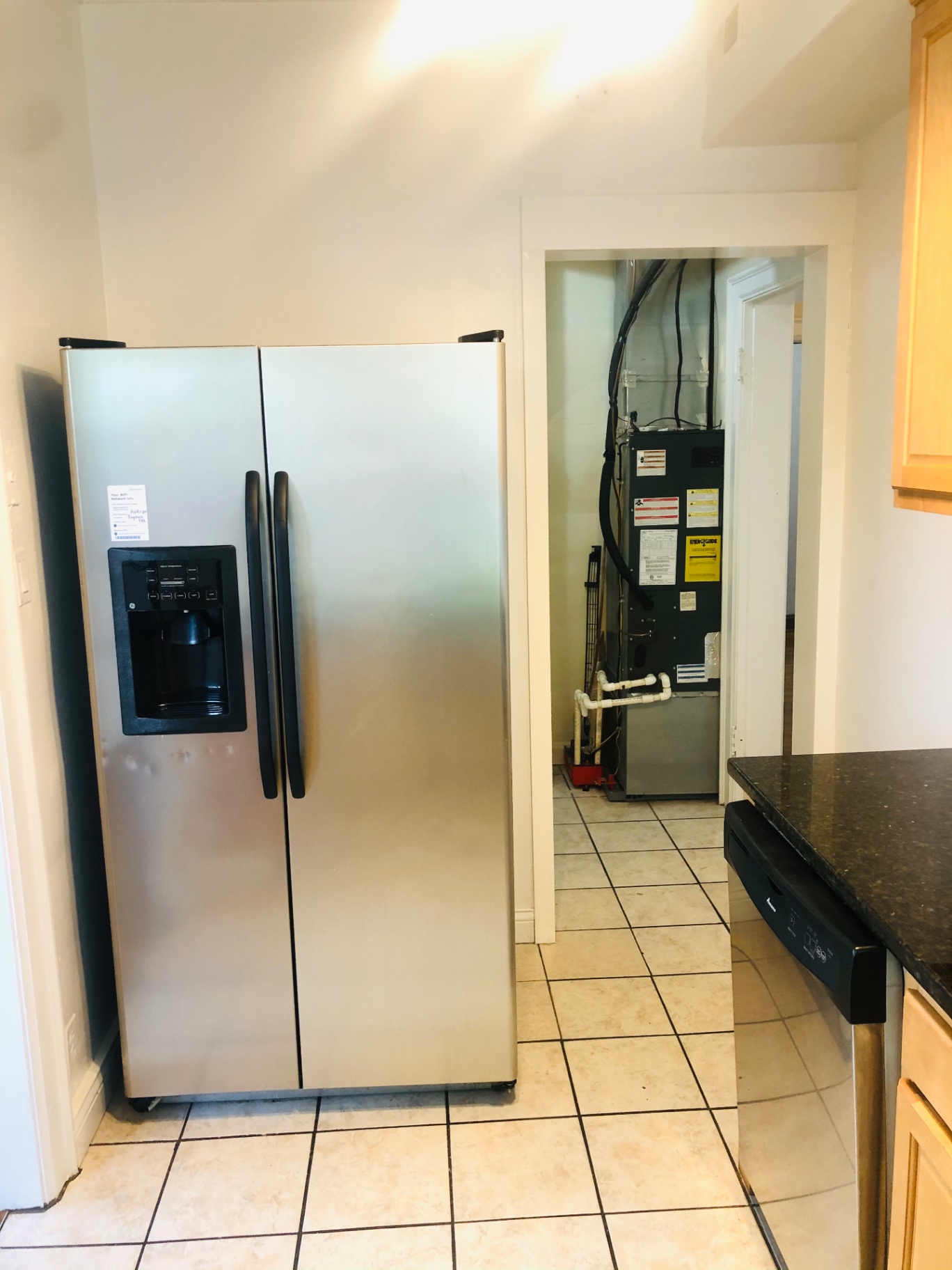 Unit L kitchen with stainless steel refrigerator and maple cabinets