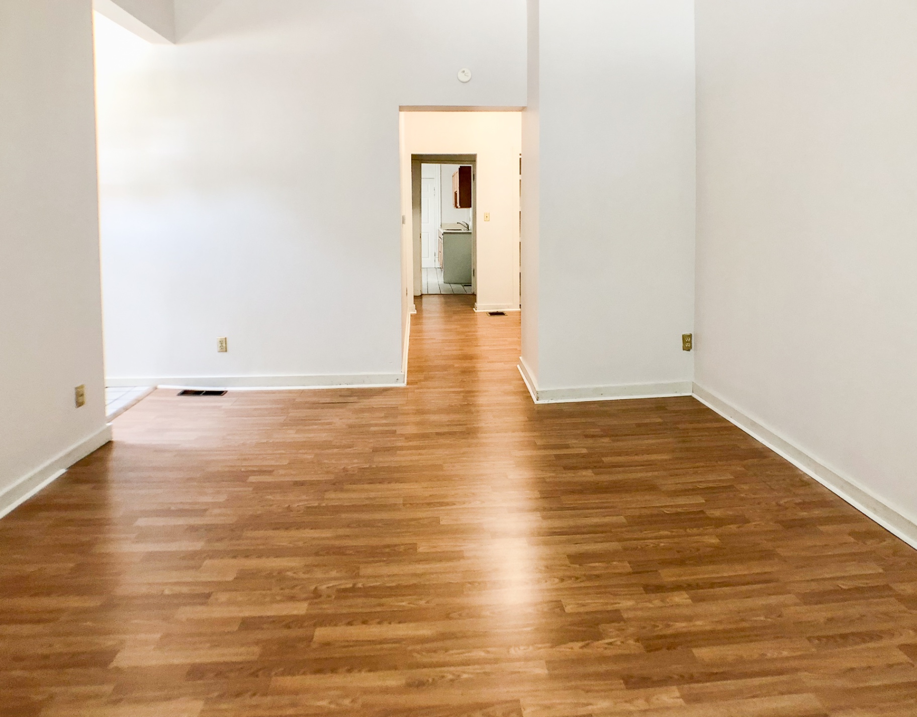 Unit A open living space looking down the hallway toward the kitchen