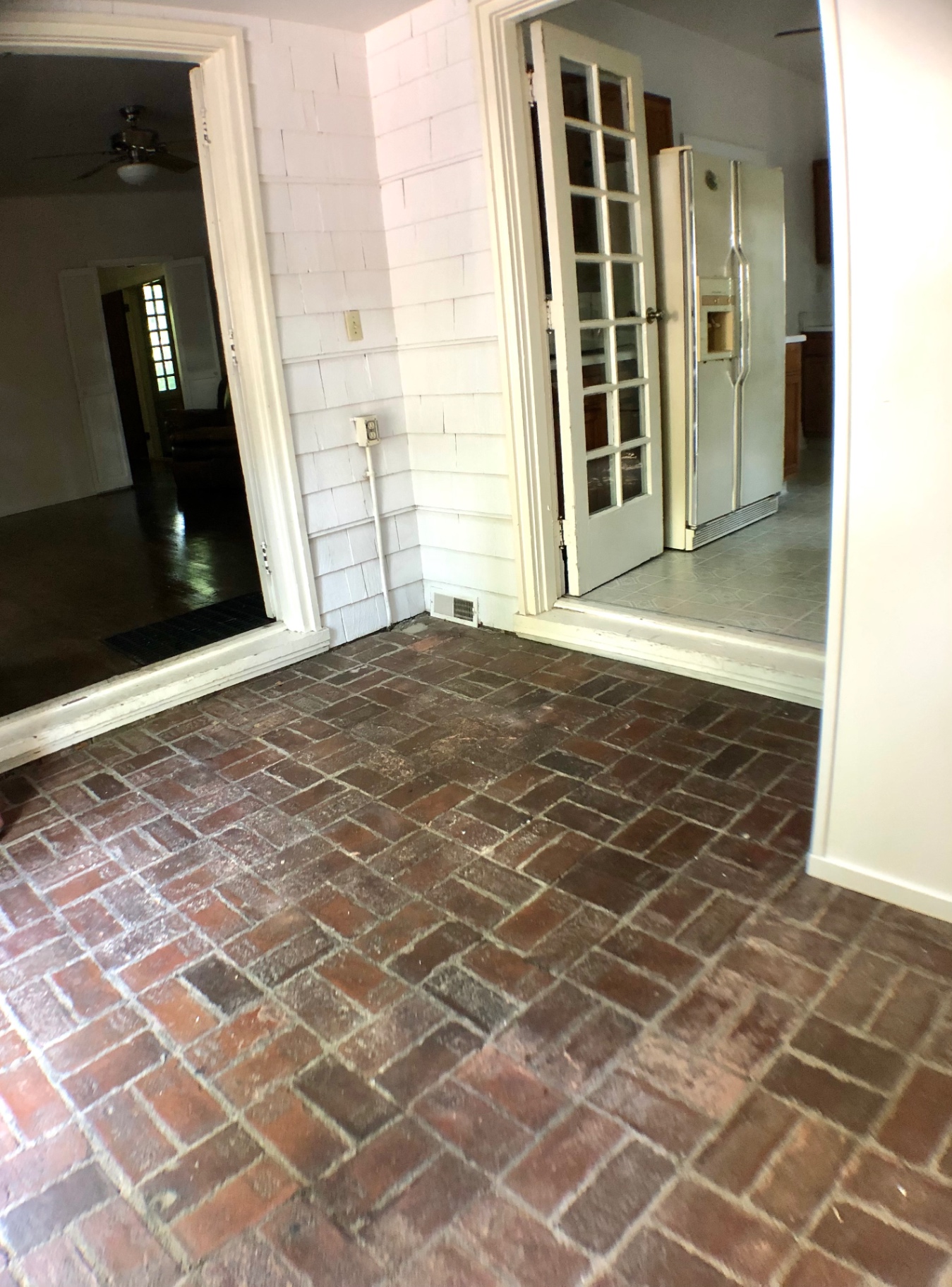 2026 Iuka Ave A brick-floored sunroom connecting the living room and kitchen