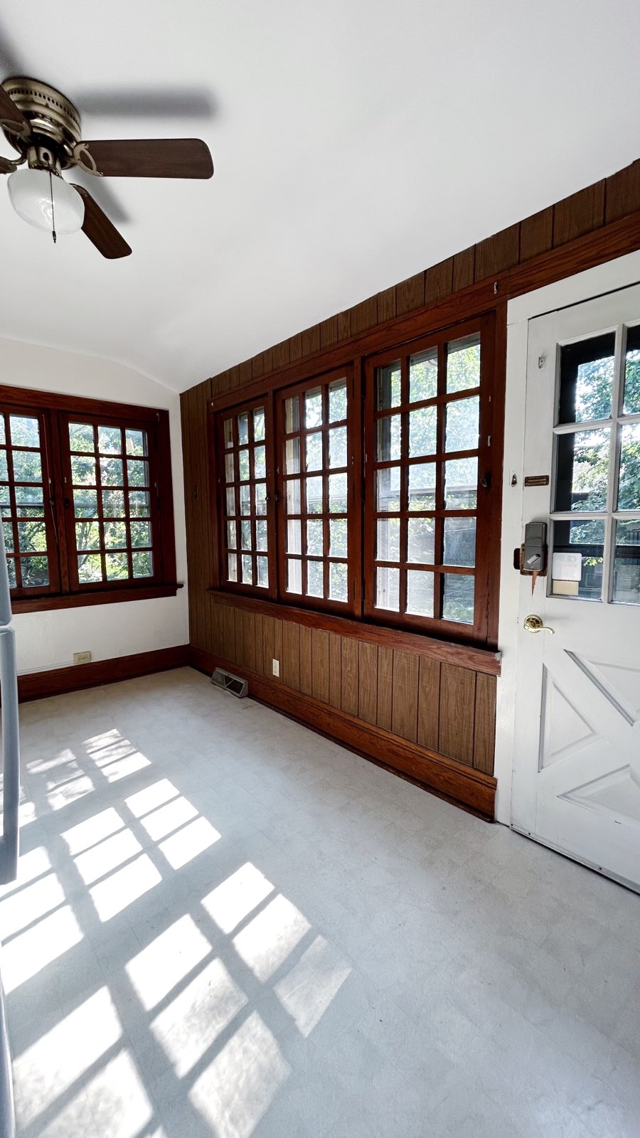 2026 Iuka Ave C sunroom with wood-paneled walls, casement windows, and ceiling fan