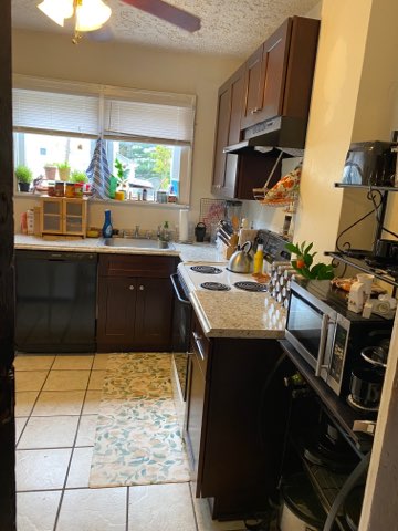 2155 N 4th St. kitchen with bright window, dark cabinets, and stainless appliances