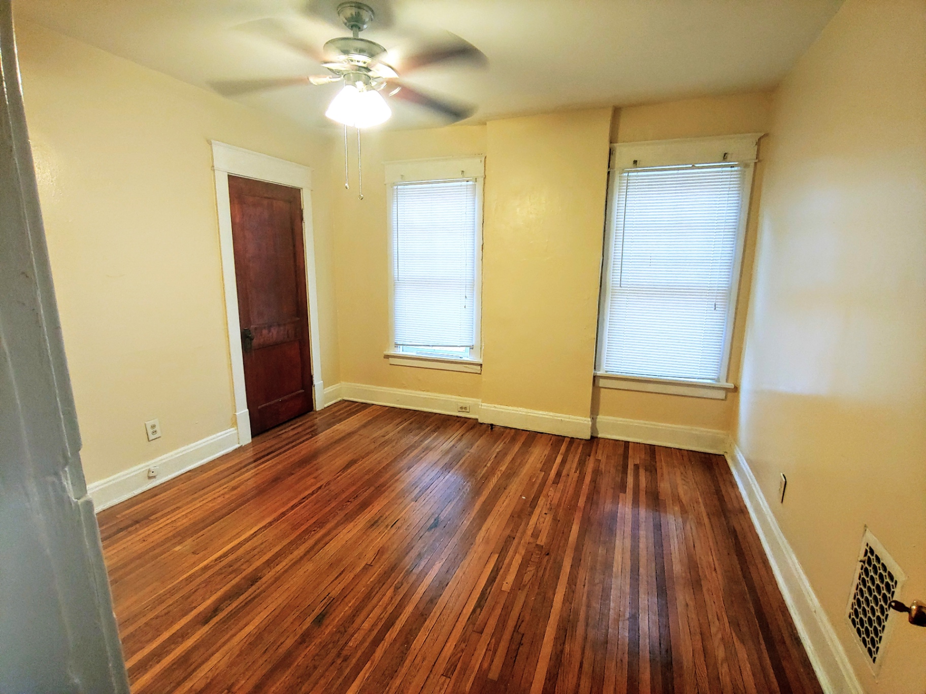 1818 Summit St. bedroom with dark hardwood floors, ceiling fan, and original interior door