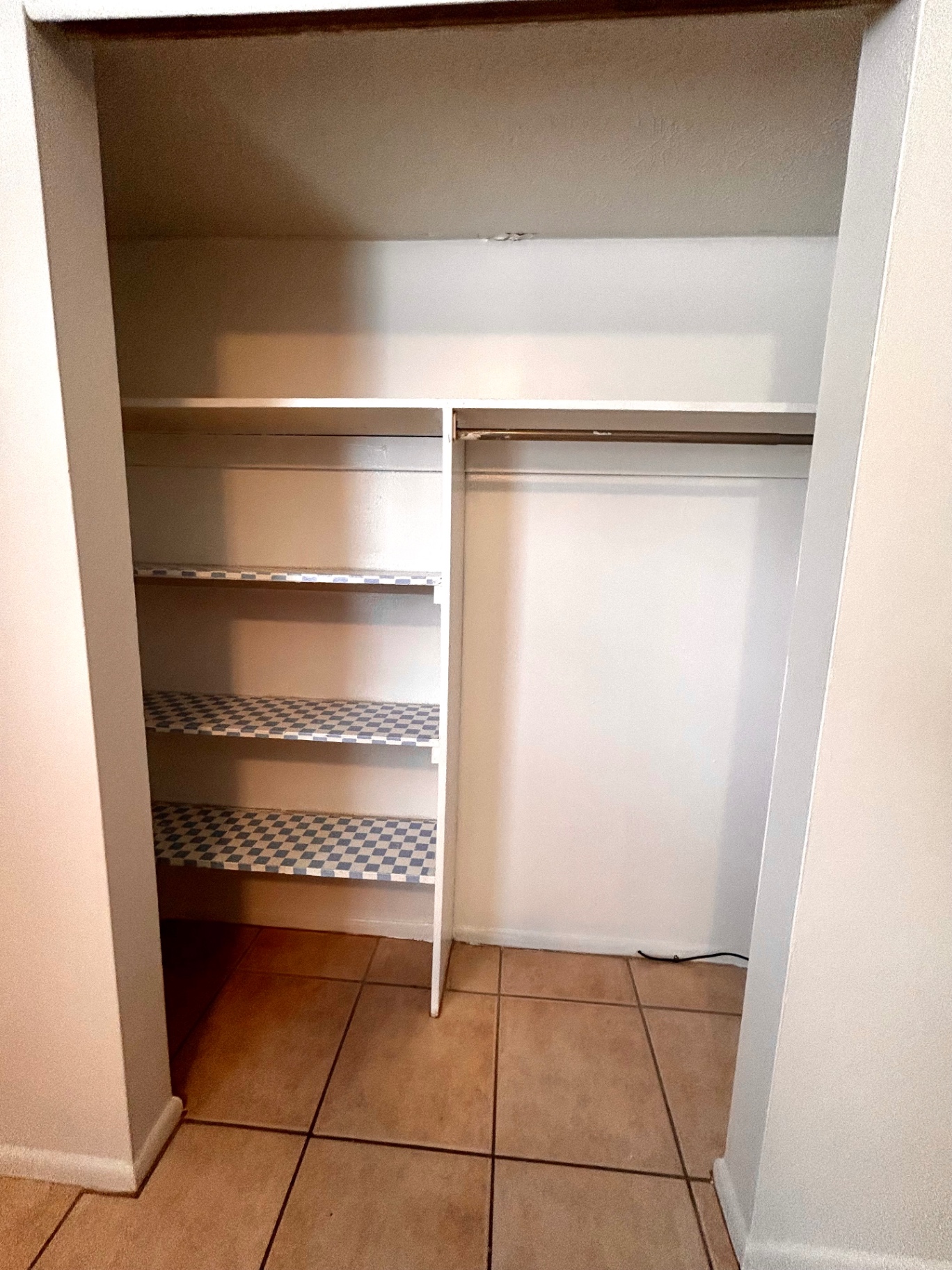 2150 N 4th St. Unit C pantry closet with lined shelving and hanging rod