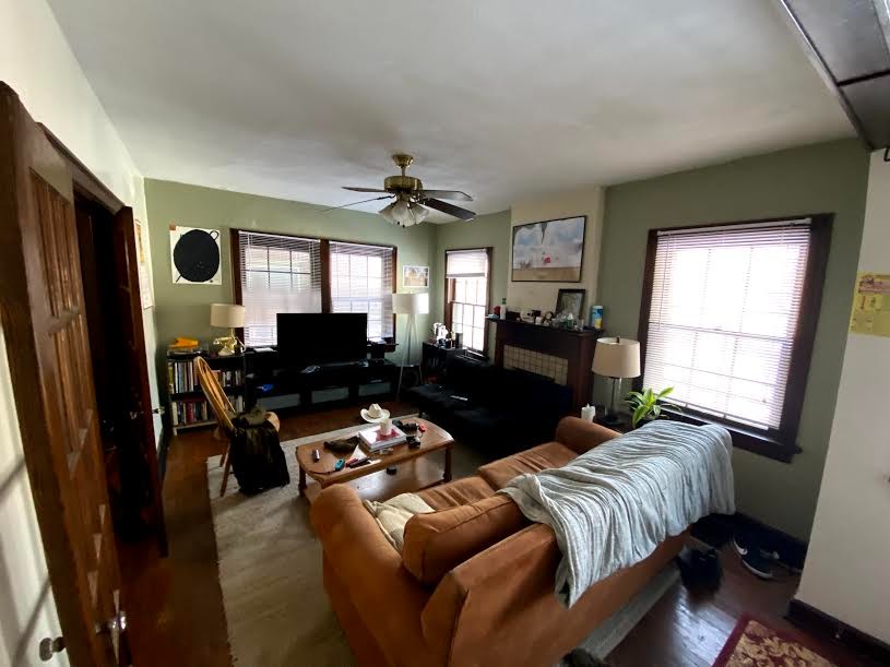 2054 Iuka Ave. B spacious living area with fireplace, three windows, and hardwood floors