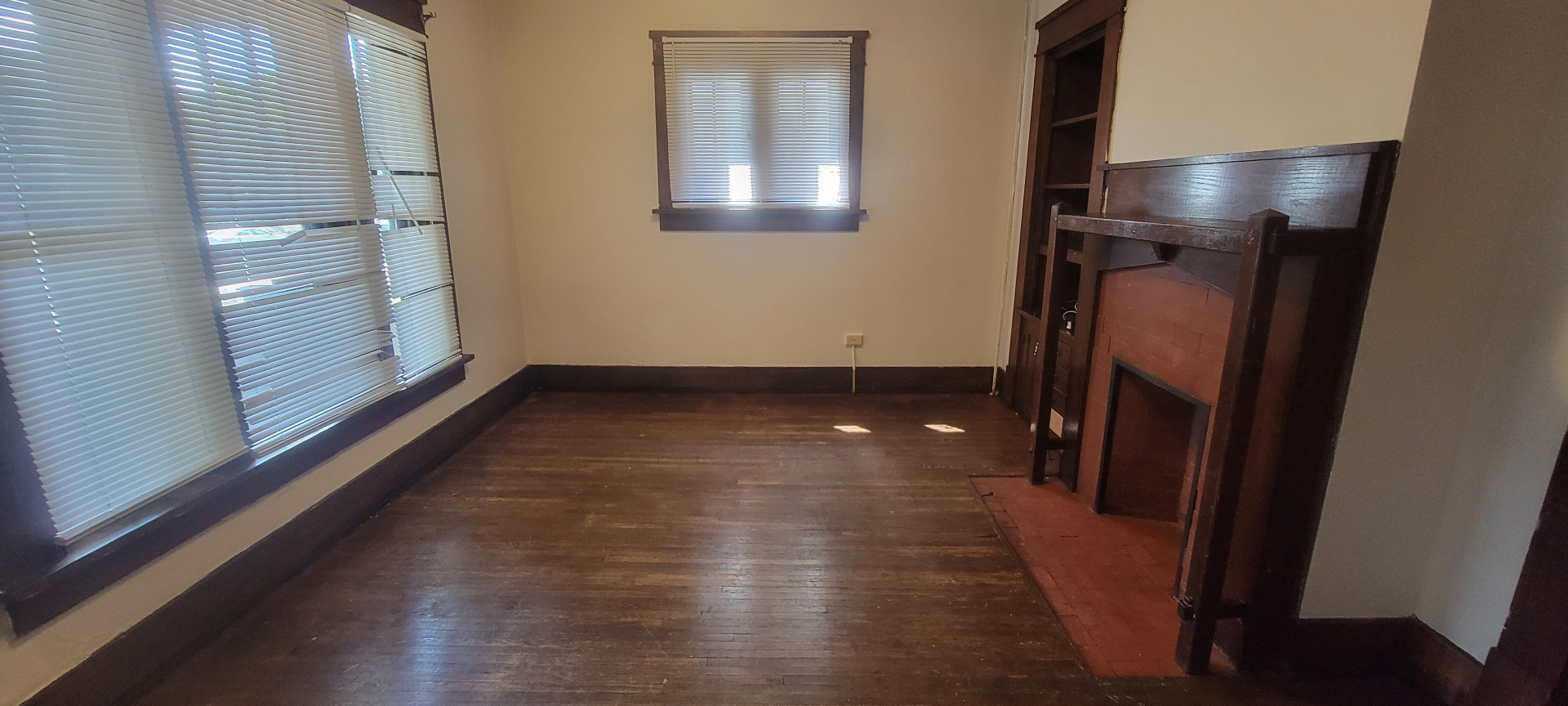 2015 Summit St. dining room with decorative brick fireplace, built-in shelving, and hardwood floors