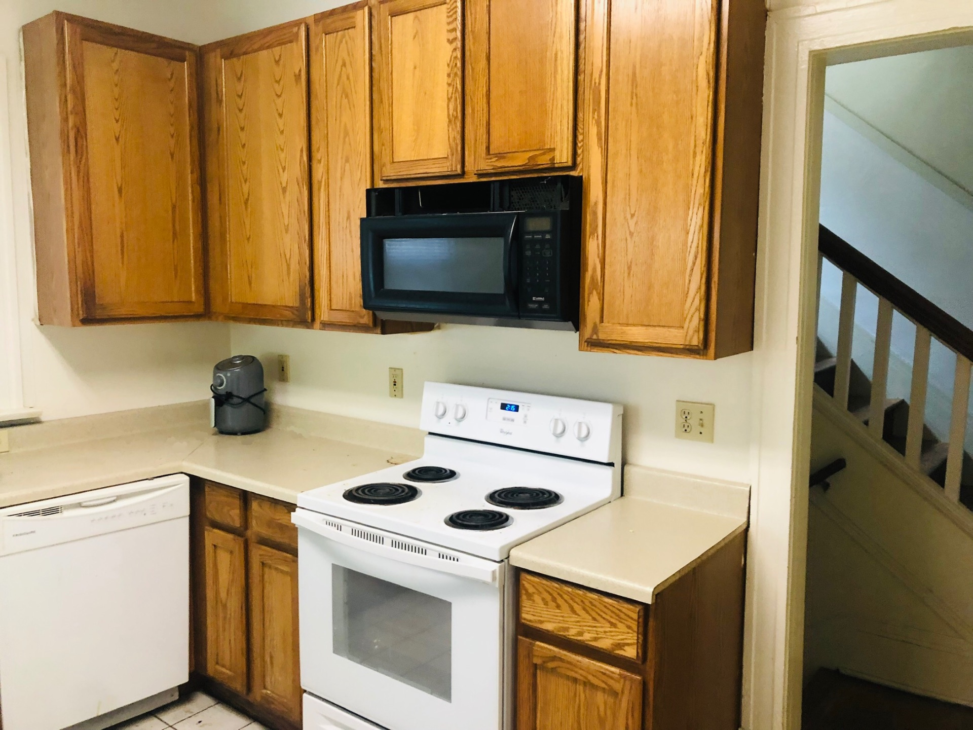 2005 Summit St. kitchen with oak cabinets, white range, dishwasher, and over-range microwave