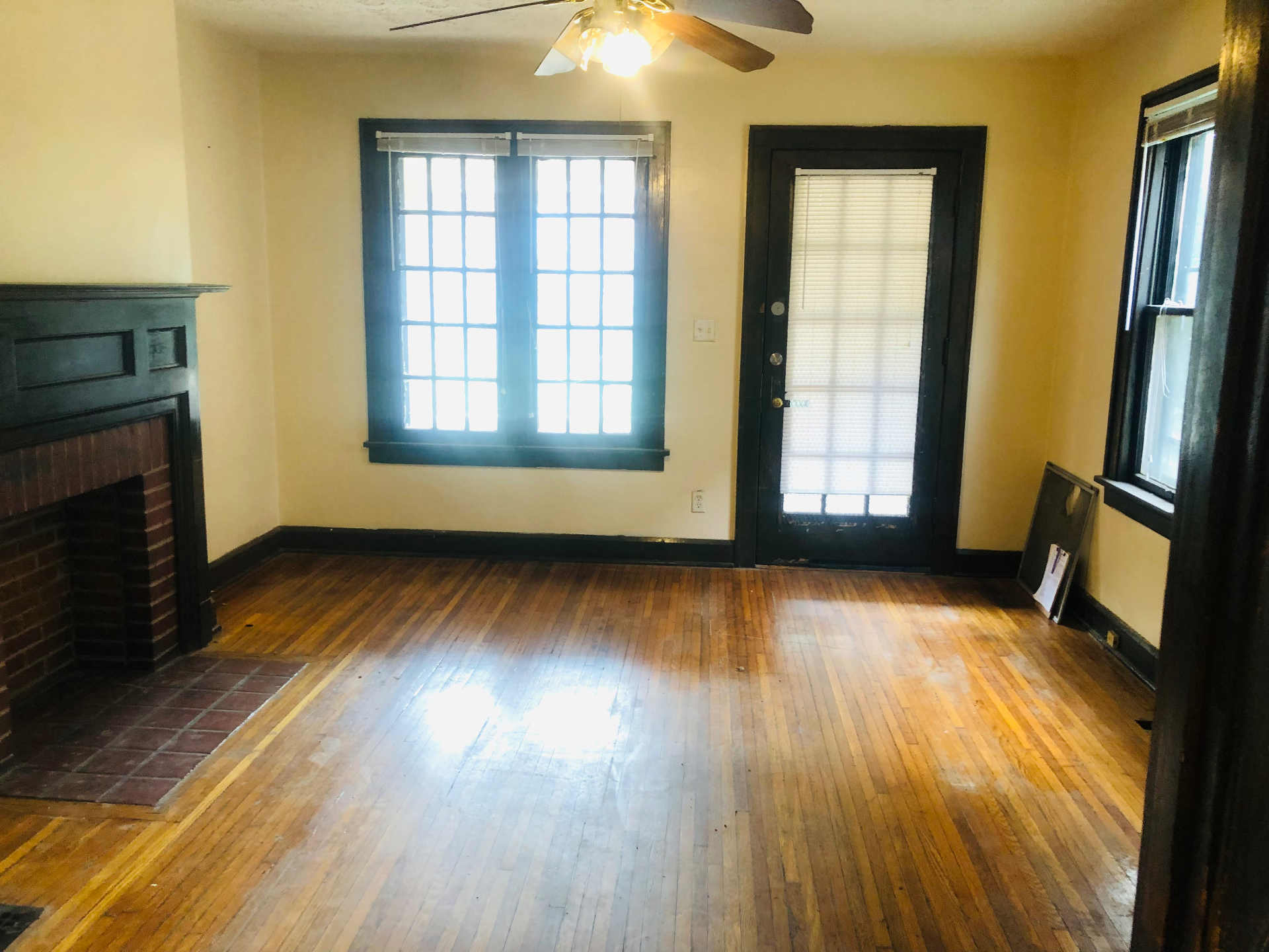2155 N 4th St. living room with original wood mantel fireplace and side door