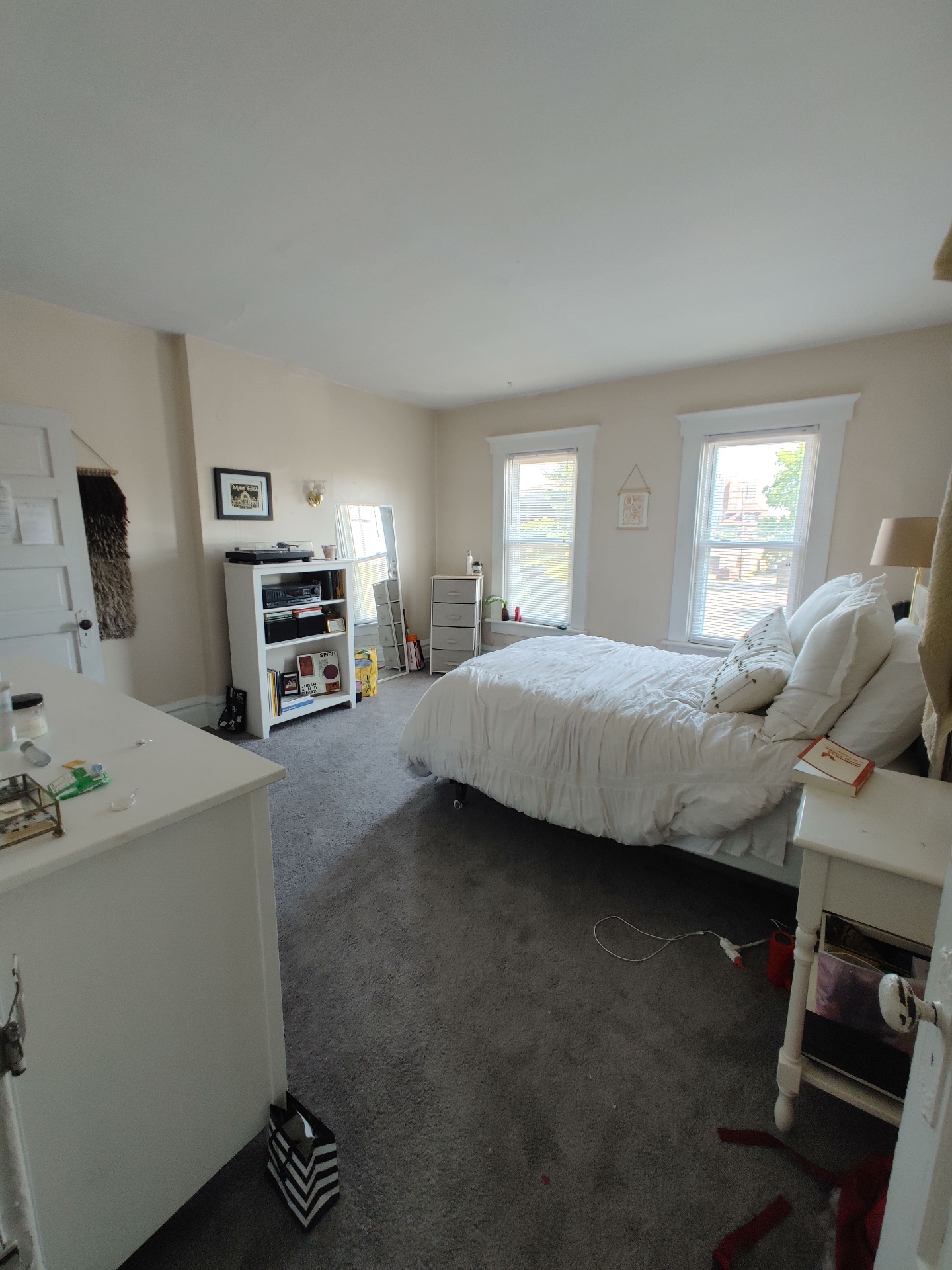 121 W 9th primary bedroom with two tall windows, plush carpet, and white bed