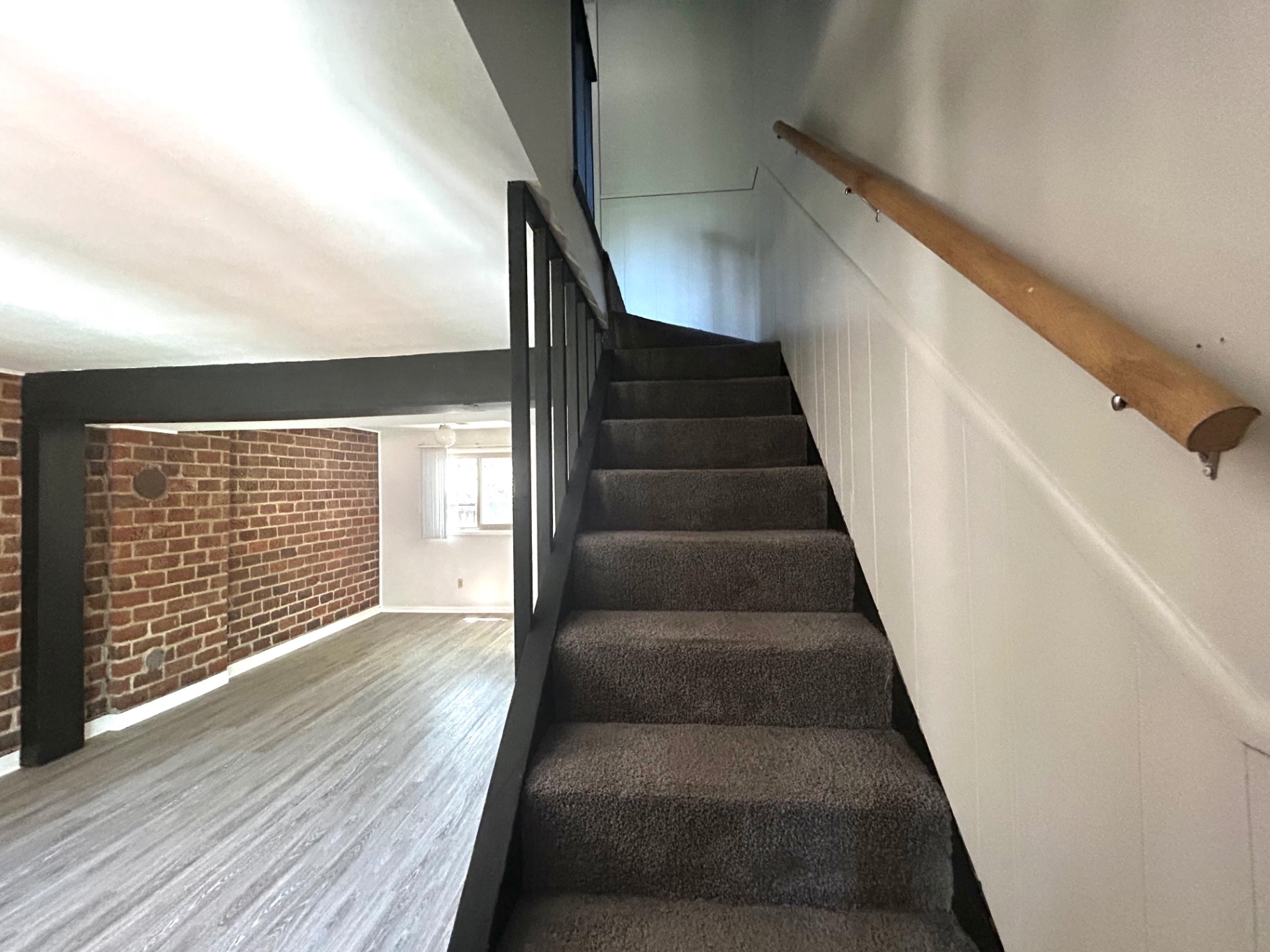 2011 Summit St. Unit E carpeted staircase with black railing and wood handrail