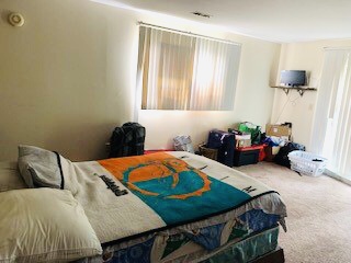 2026 Summit St. bedroom area with large window, wall-mounted TV shelf, and carpet