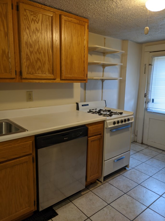 374 C E 14th Ave. kitchen with oak cabinets, gas range, stainless dishwasher, and tile floor