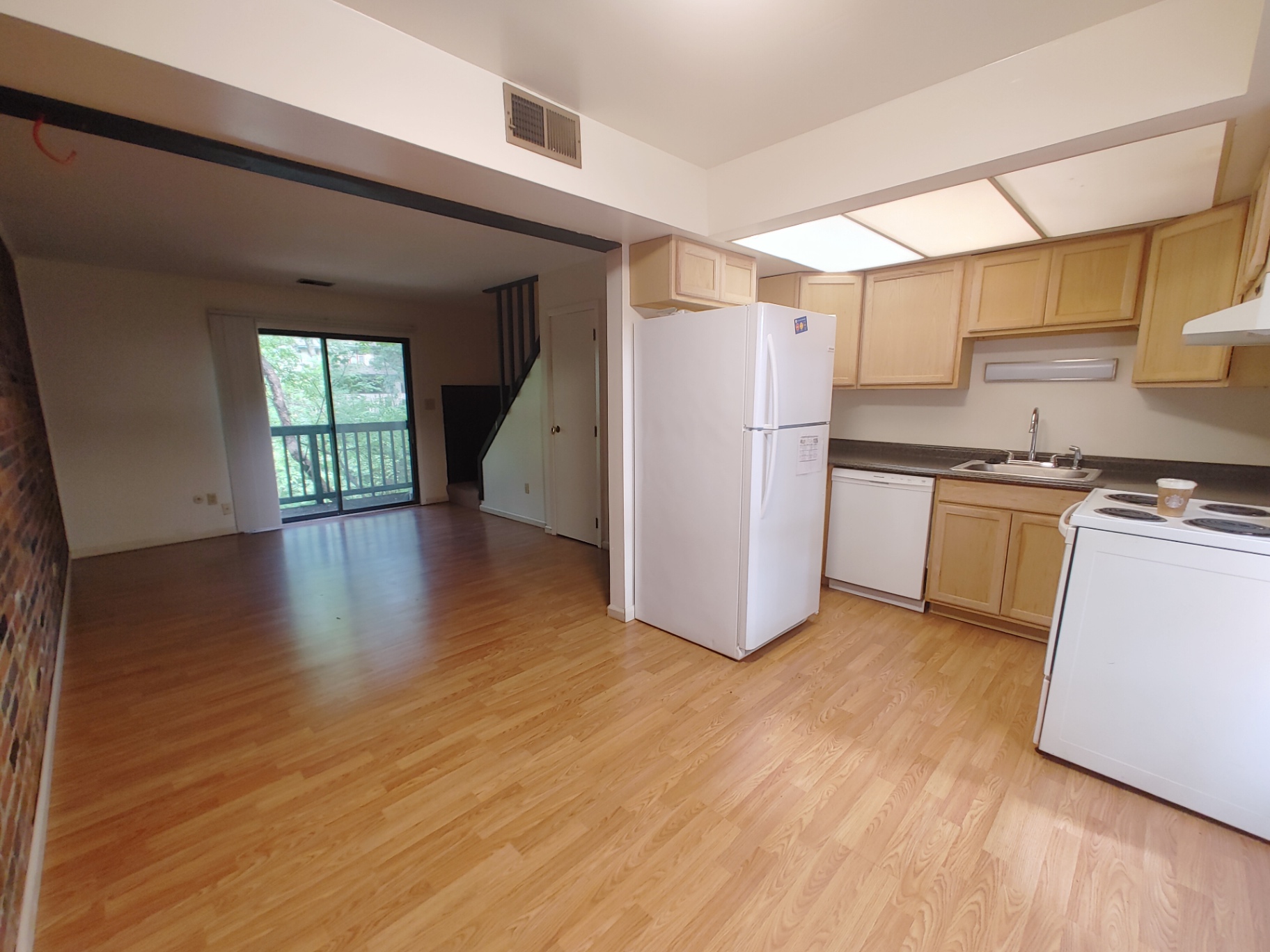 2020 Iuka Ave. open kitchen and living area with sliding doors to a balcony overlooking greenery