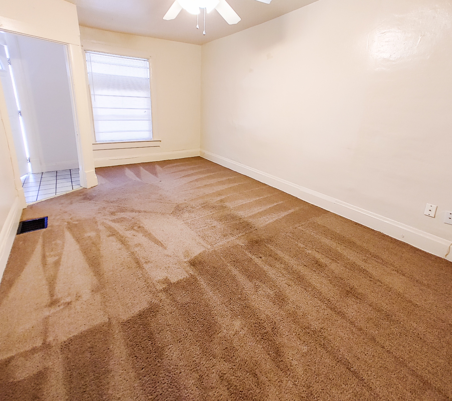Rear unit bedroom with ceiling fan, fresh carpet and bright window