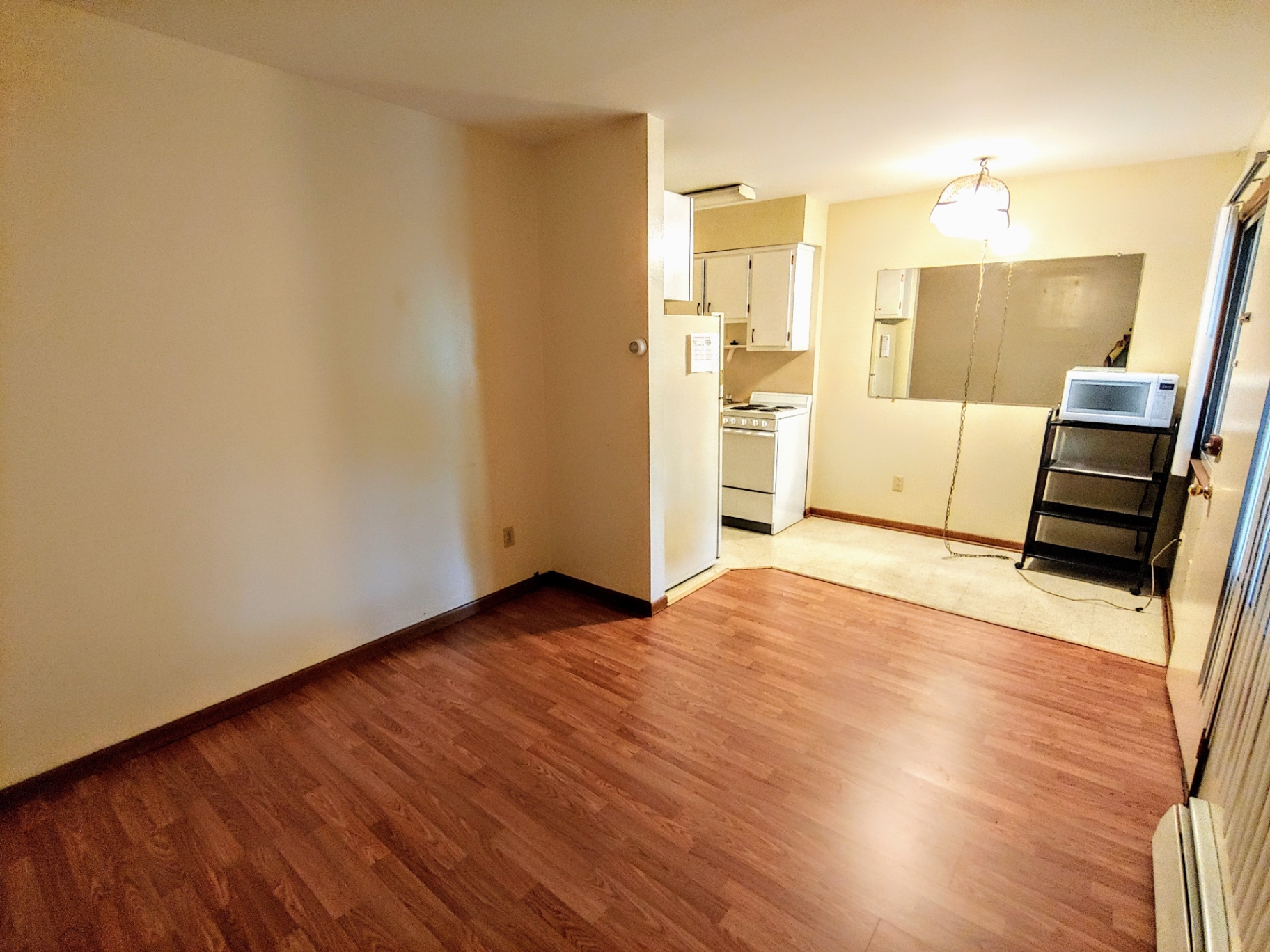 2040 Iuka Ave. 1A open living area with wood laminate floors and natural light