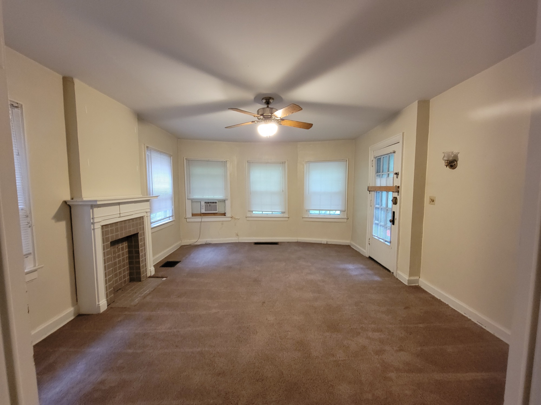 2048 Iuka Ave. B living room with decorative tile fireplace, ceiling fan, and bay of windows