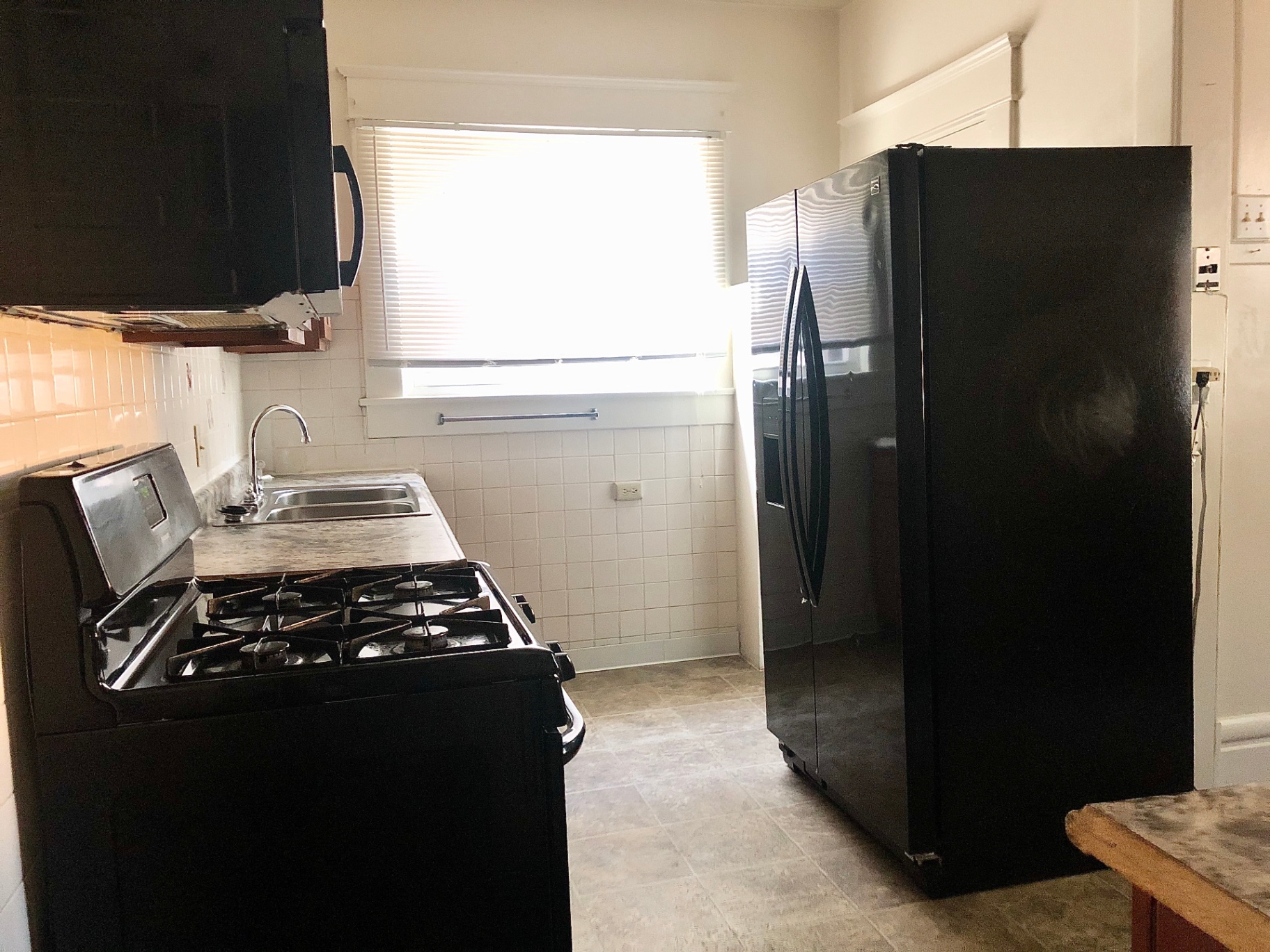 2015 Summit St. kitchen with gas range, double sink, and black side-by-side refrigerator