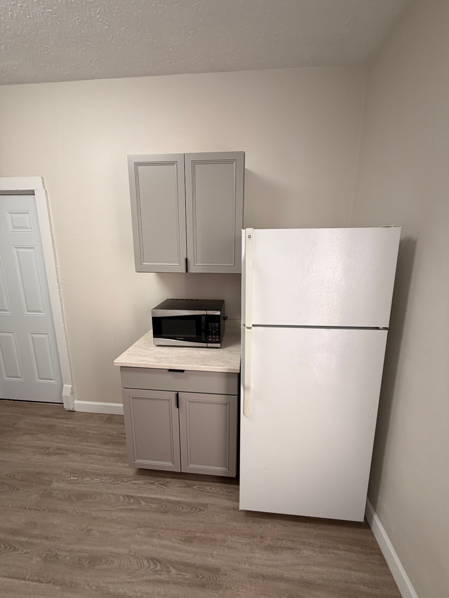 133½ kitchen storage area with fridge, microwave and pantry cabinets