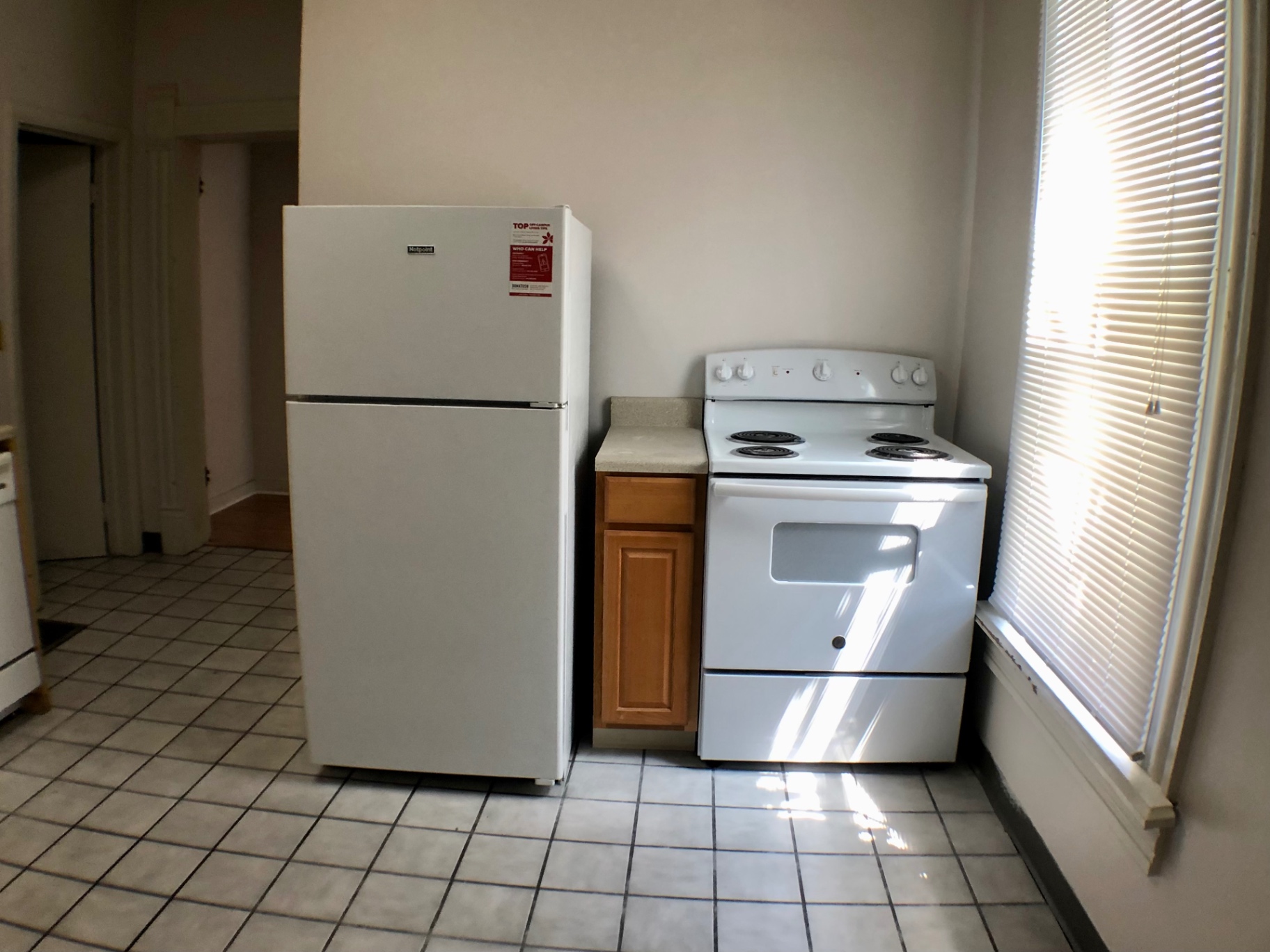 Unit A kitchen with fridge, electric range and hallway to living area