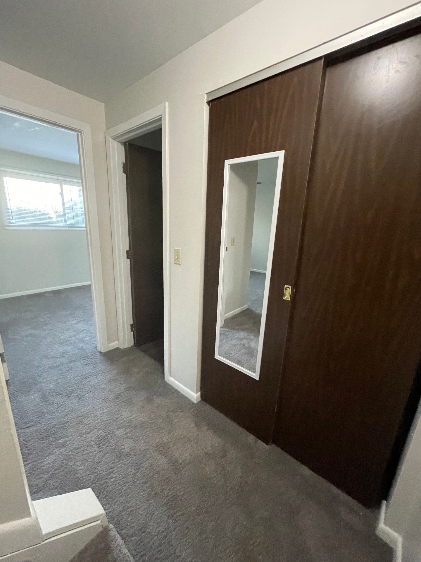 2020 Summit St. bedroom hallway with mirrored closet doors and fresh carpet