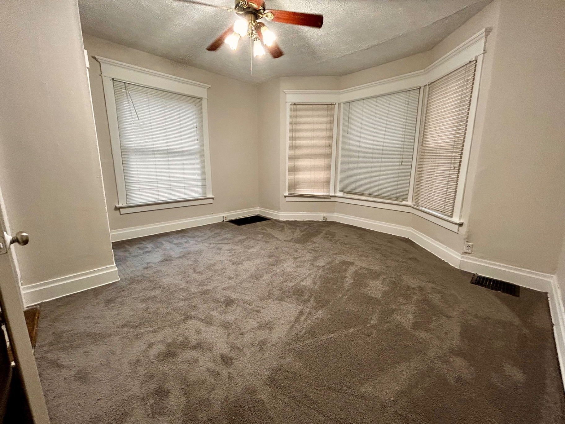 68 E Patterson Ave. carpeted room with large bay window, ceiling fan, and side window