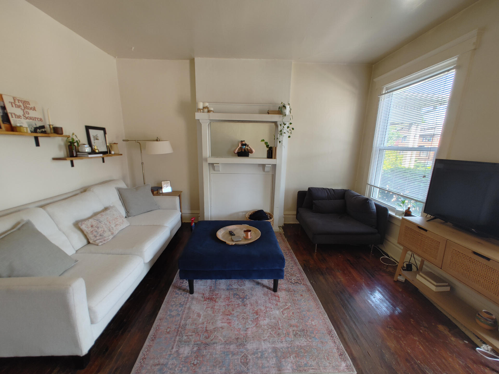 121 W 9th living room with original white mantel, hardwood floors, and vintage rug