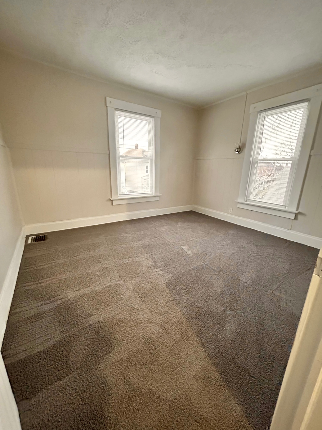 68 E Patterson Ave. carpeted bedroom with two bright windows and painted wainscot trim