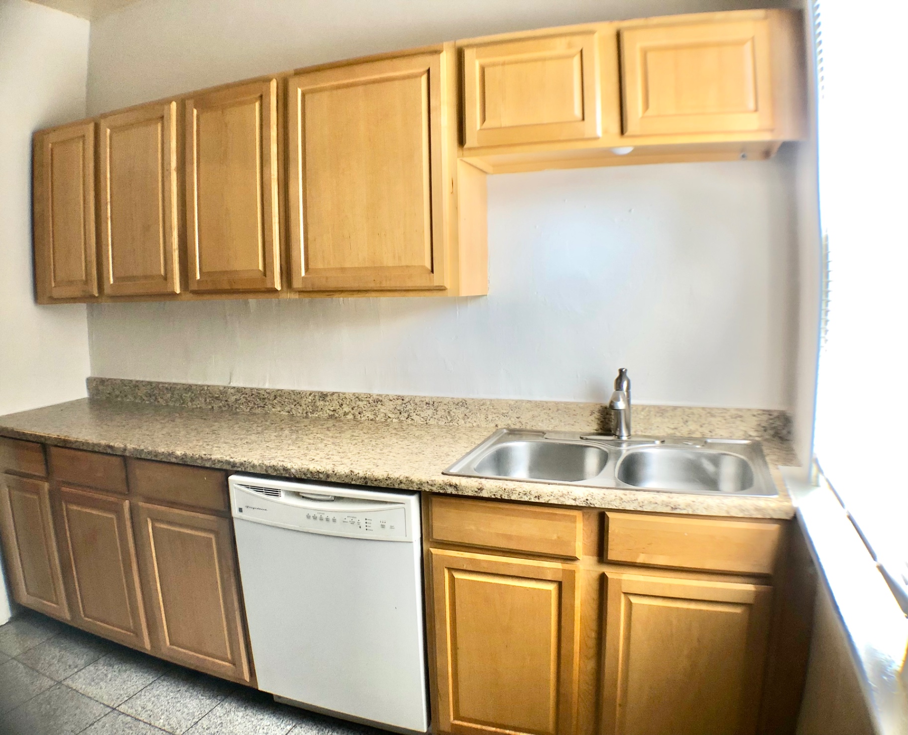 117 W 9th empty kitchen showing maple cabinets and granite countertops