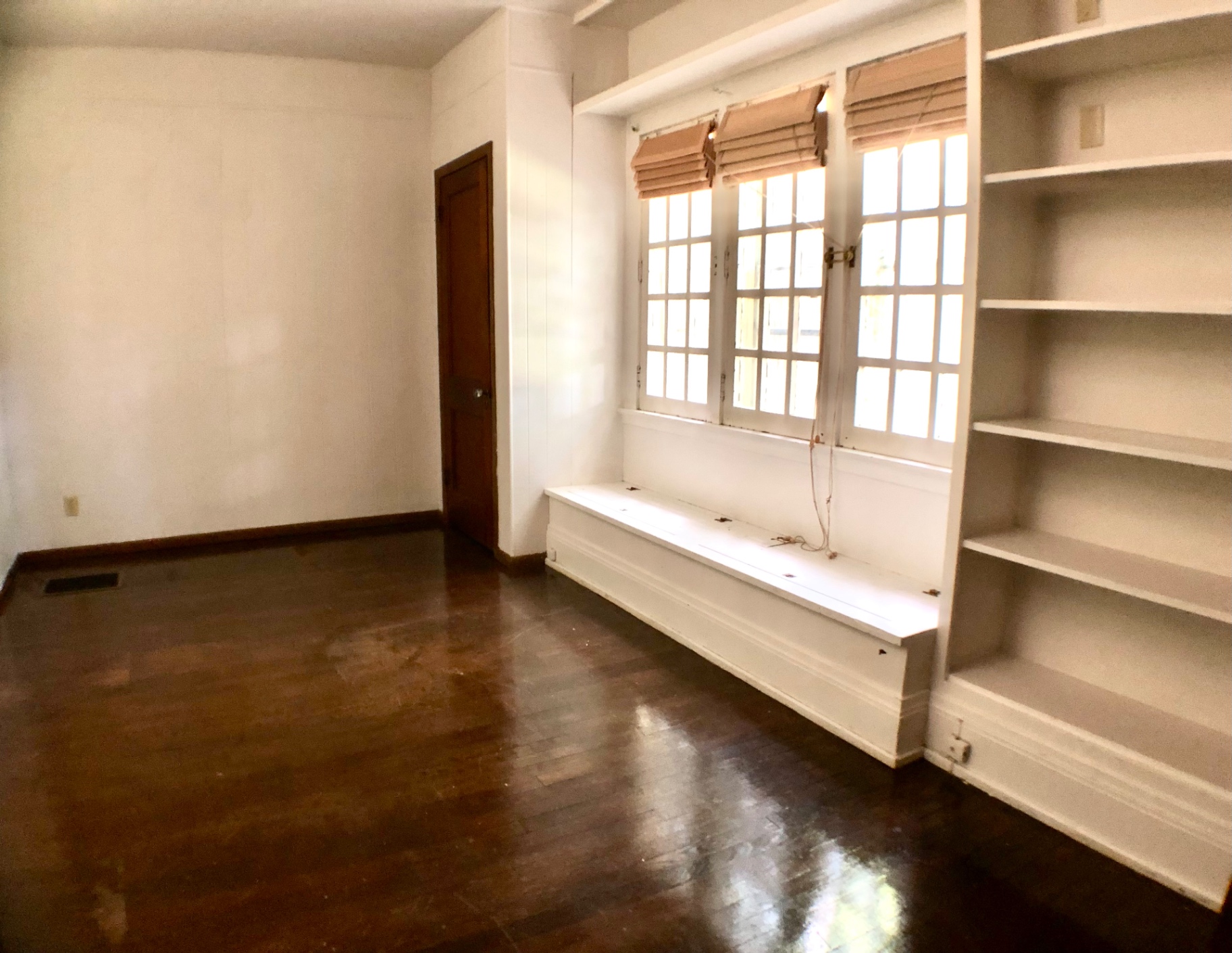 2026 Iuka Ave A bright bedroom with window seat, shelving, and hardwood floors