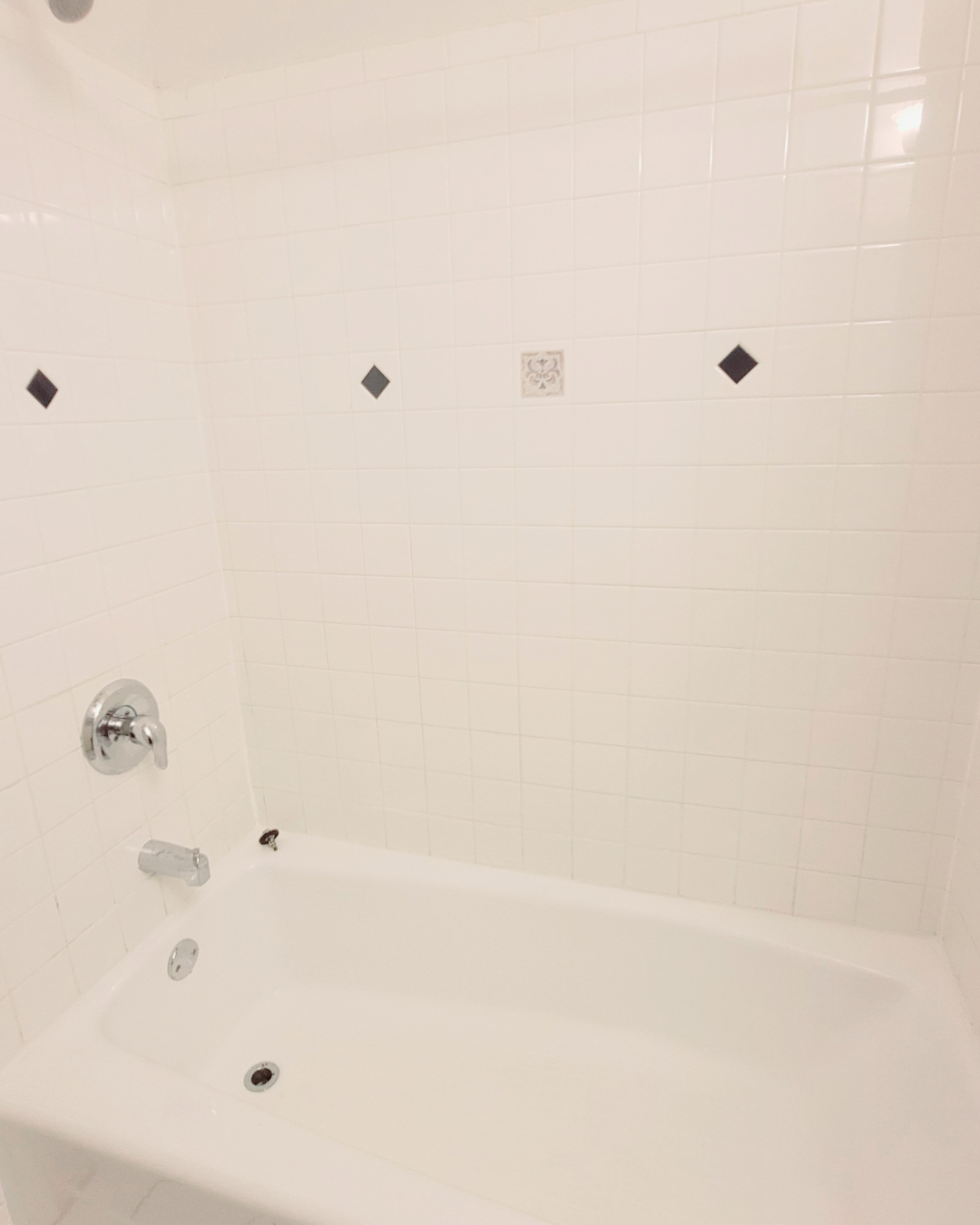 Unit A bathroom shower and tub with white tile surround