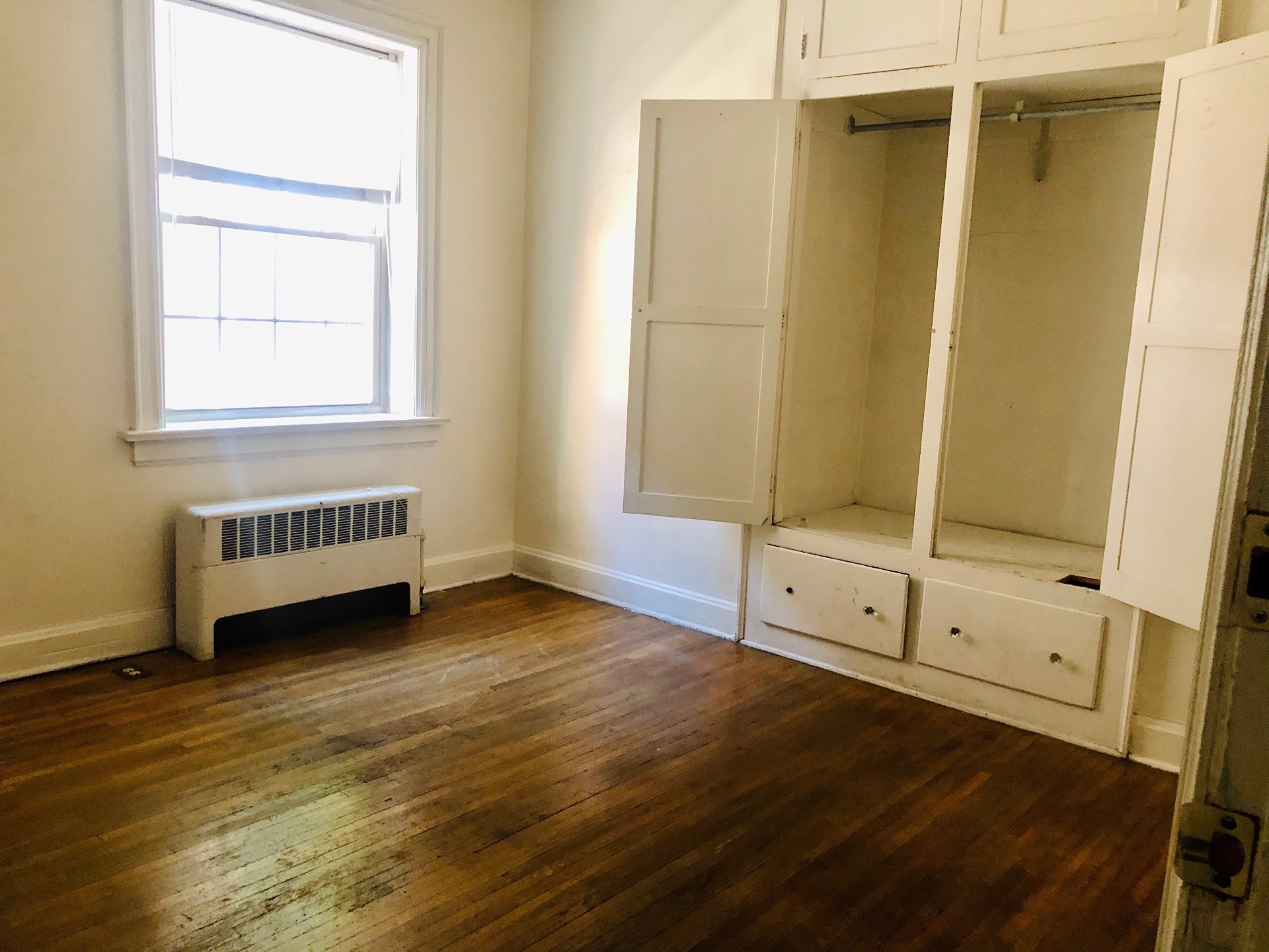 Unit G bedroom with hardwood floors and built-in closet