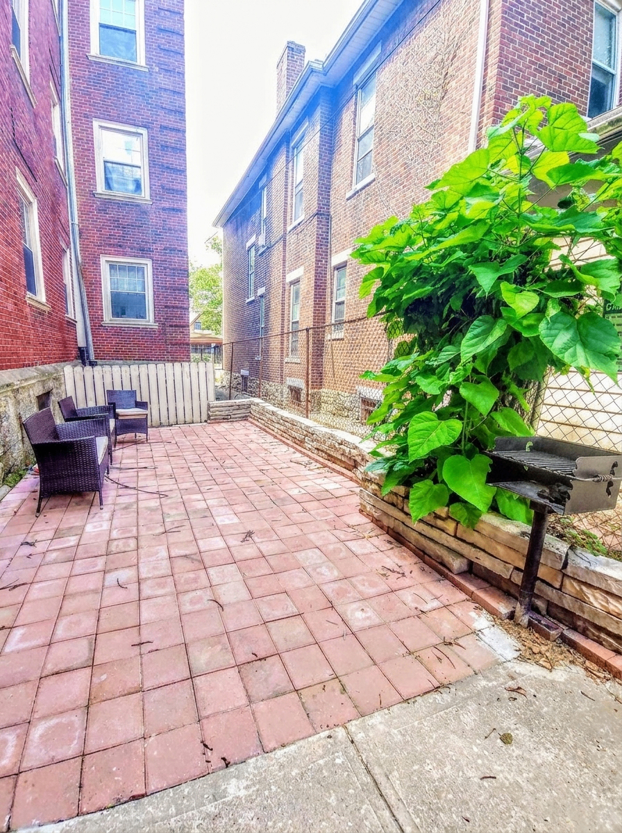Unit H shared brick patio with seating and grill