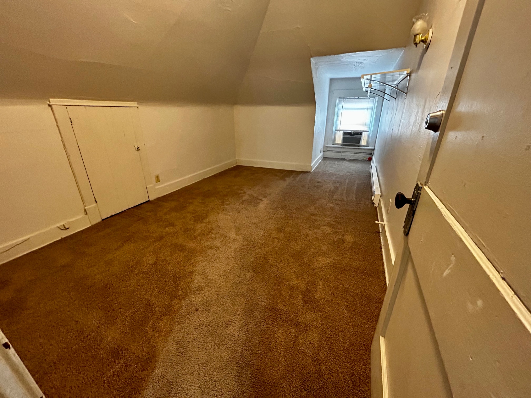 1820 Summit St. long carpeted upper room with built-in knee-wall storage doors