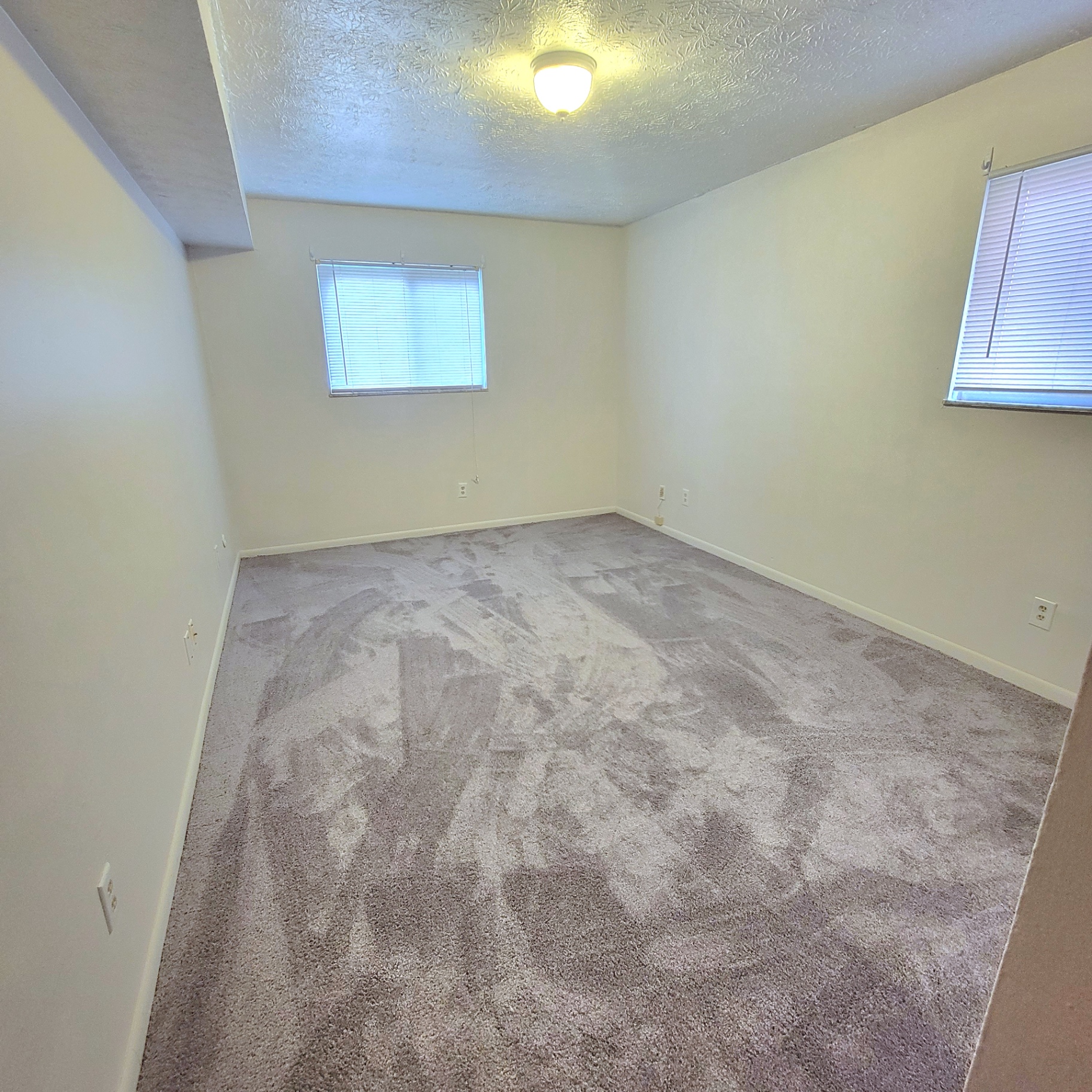 2150 N 4th St. Unit E carpeted bedroom with two windows and ceiling light