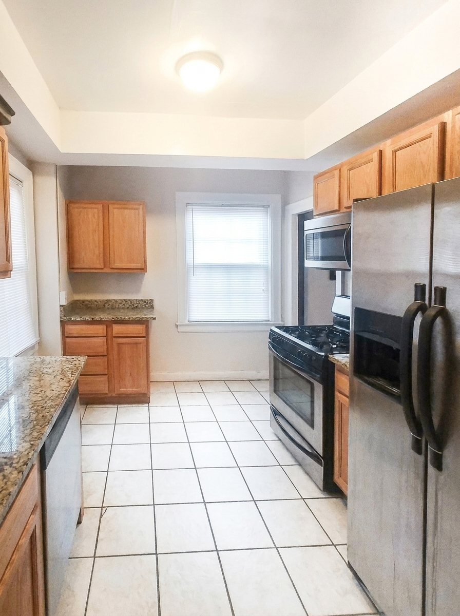 Unit C kitchen with stainless steel appliances and granite countertops