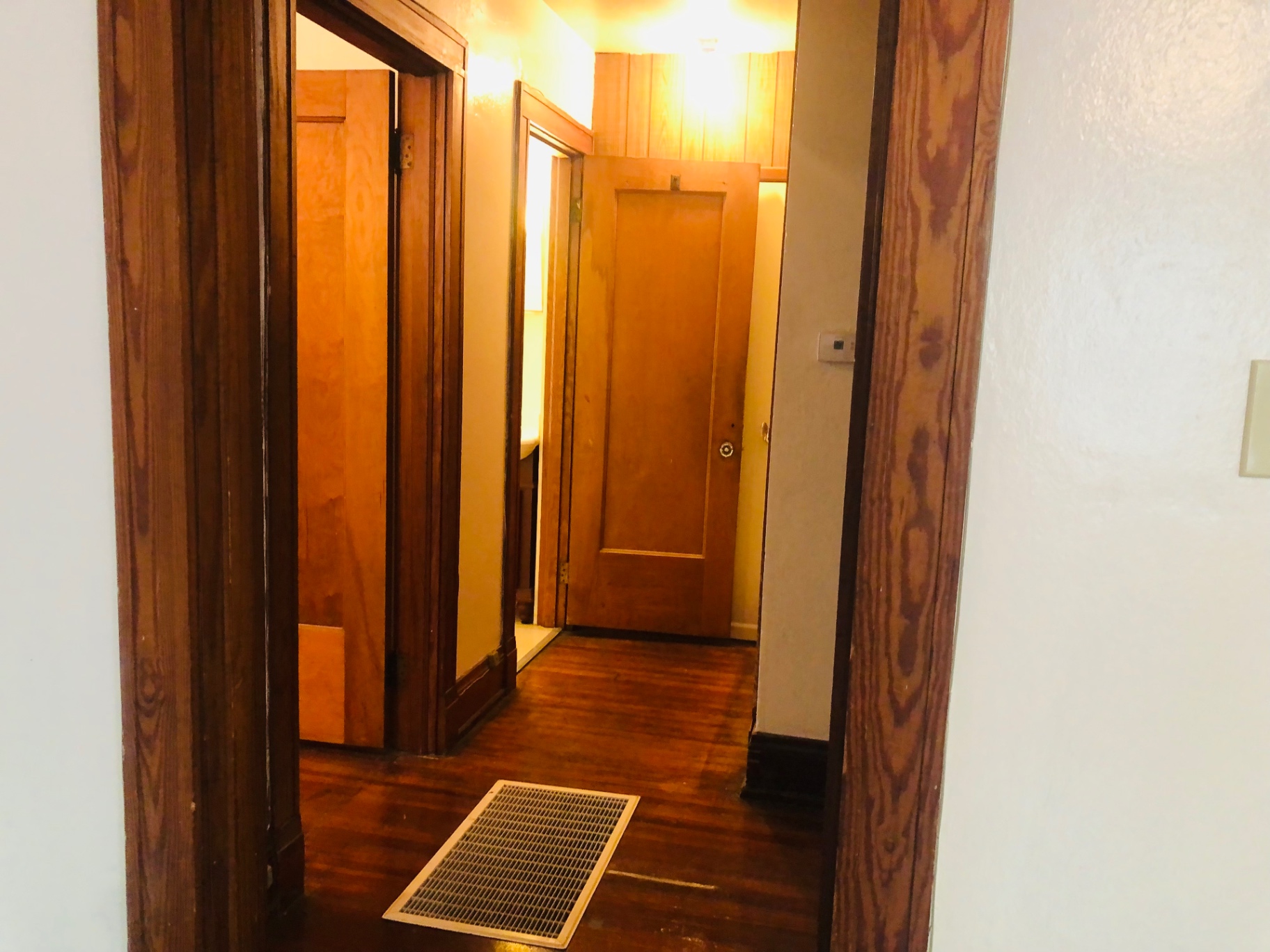 2026 Iuka Ave C hallway with warm wood trim connecting bedrooms and bath