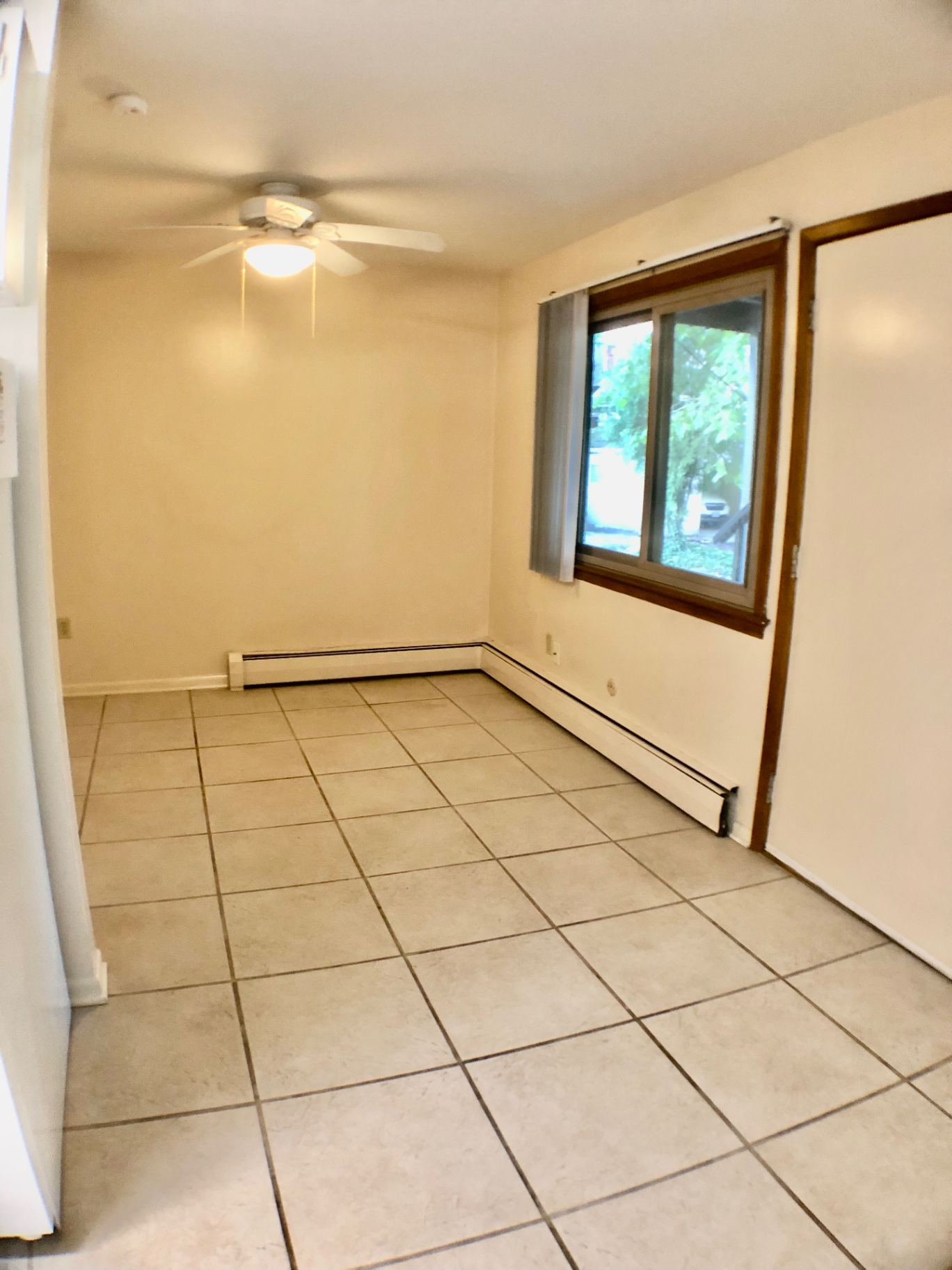2040 Iuka Ave. 5A living room with ceiling fan, tile flooring, and large window overlooking the courtyard