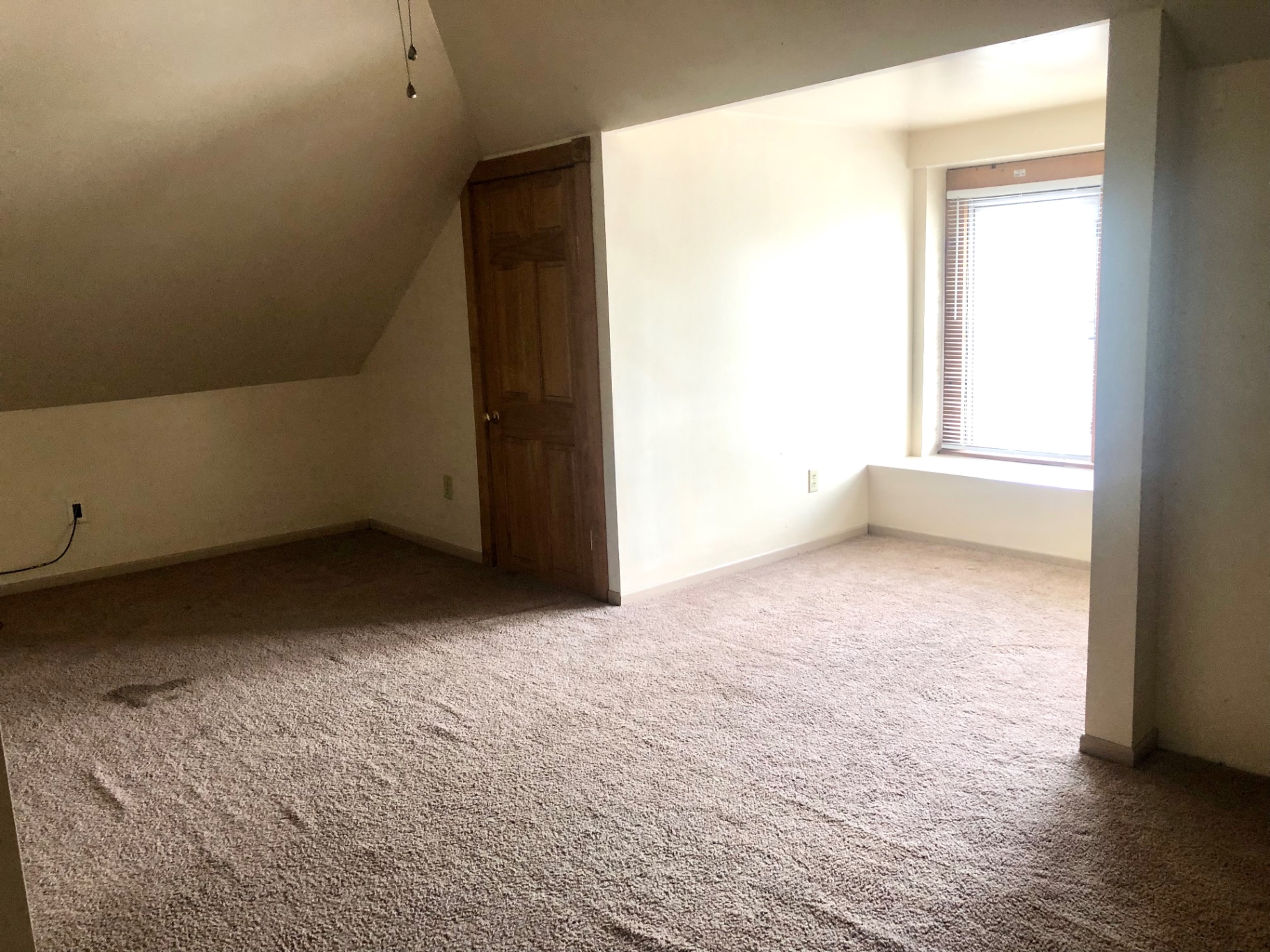 77 E Patterson Ave. upper-level carpeted bedroom with sloped ceiling, built-in closet, and sunny alcove window