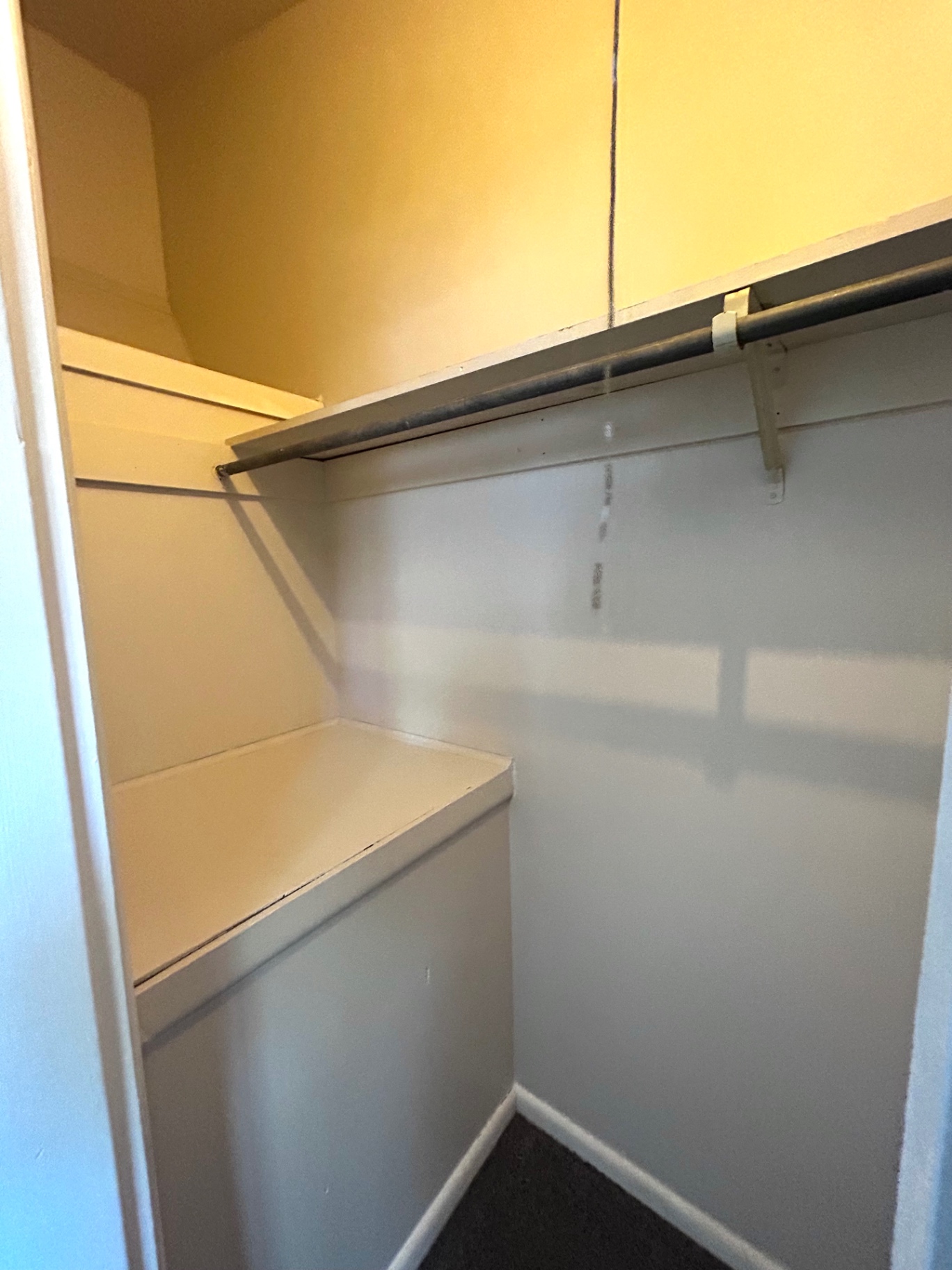 2011 Summit St. Unit E first bedroom closet with built-in shelf and hanging rod