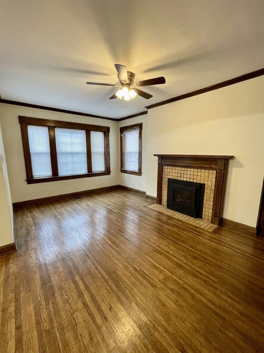 Unit D living room with tiled gas fireplace and bay windows