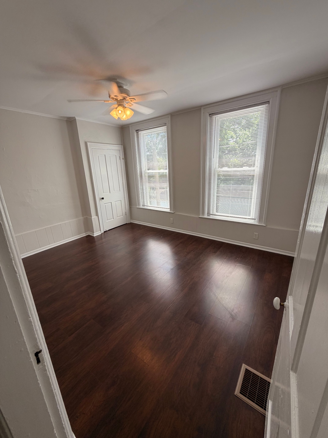 3340 Chestnut Upstairs bedroom with dark hardwood floors, ceiling fan and three sunny windows