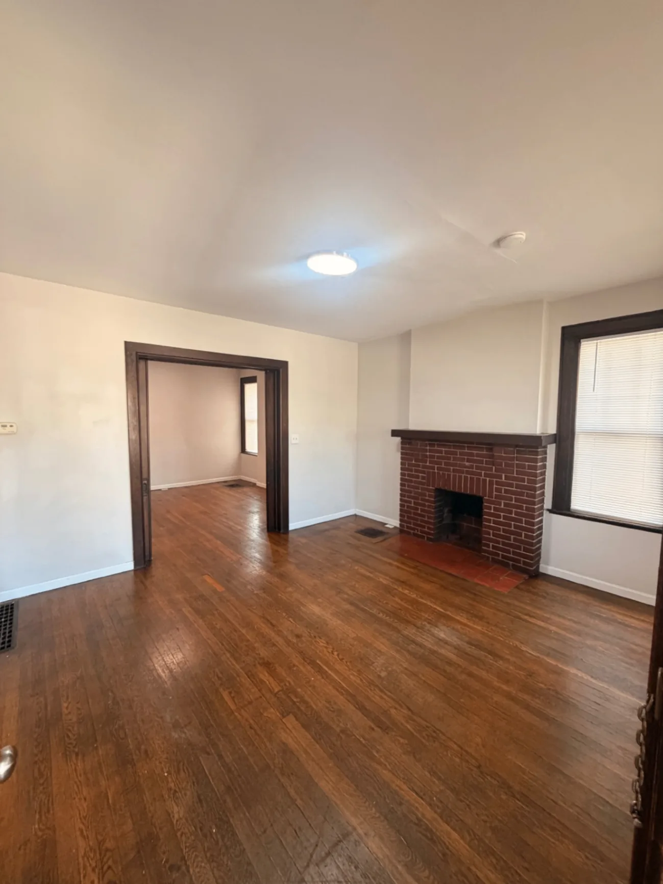 1816 Summit St. living room with brick fireplace and refinished hardwood floors