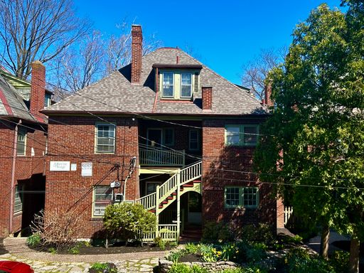 2048 Iuka Ave. exterior — brick building with shared stairway entry and landscaped front approach