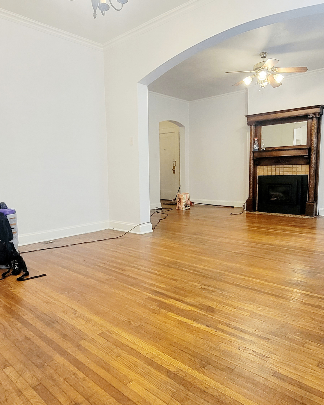 Unit A living room with decorative fireplace mantel and arched entryway