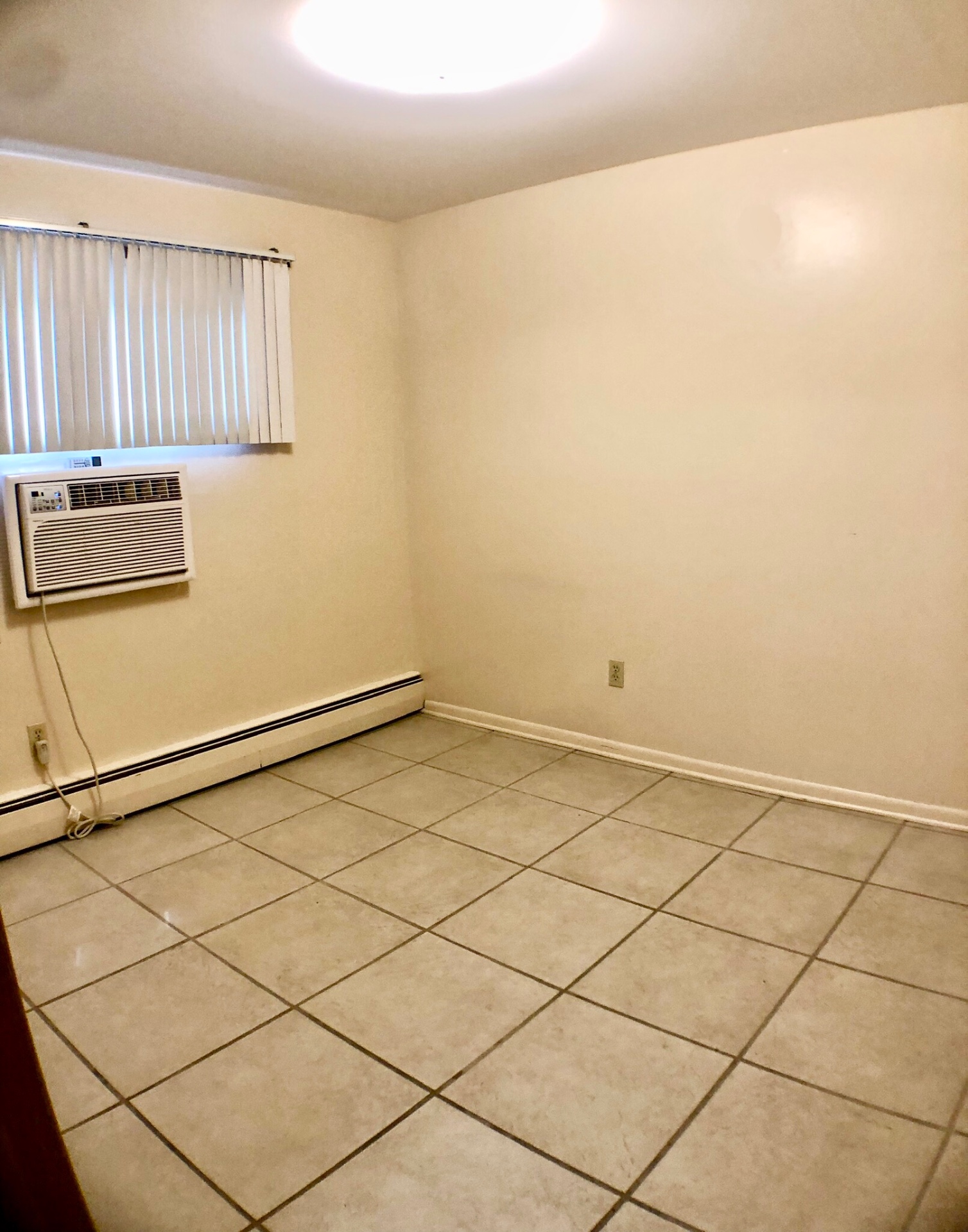 2040 Iuka Ave. 5A bedroom with tile flooring, window AC unit, and baseboard heat