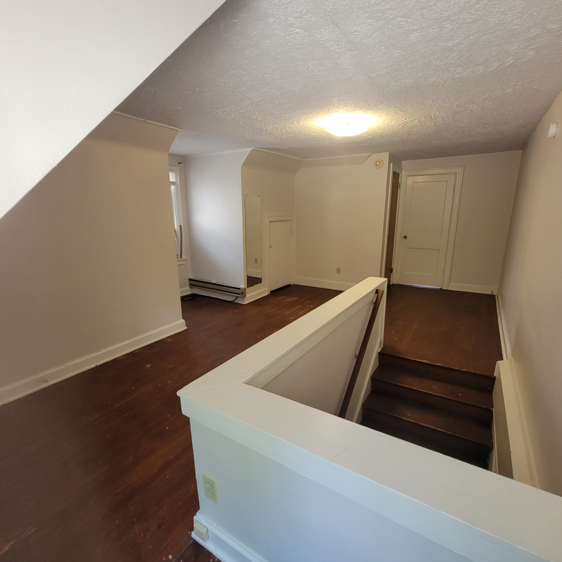 2048 Iuka Ave. C upstairs landing with hardwood floors and stairway to main level