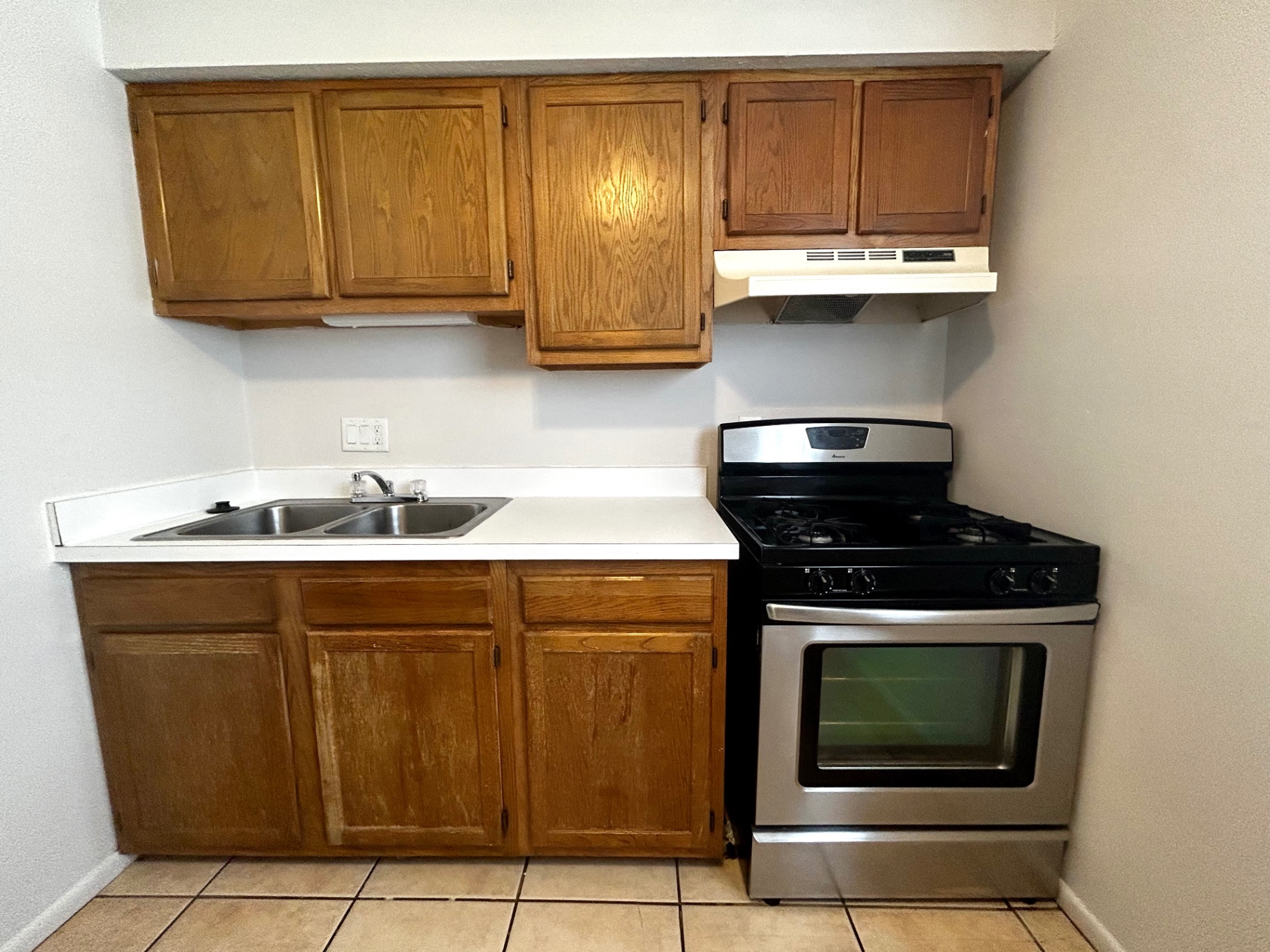 2150 N 4th St. Unit C kitchen close-up with double sink, gas range, and oak cabinets