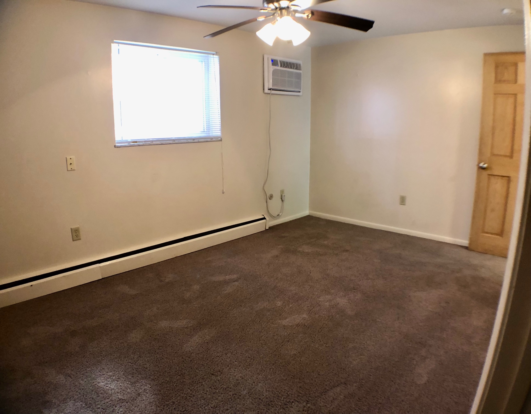 1827 N 4th St. Unit 1 carpeted bedroom with window AC and ceiling fan