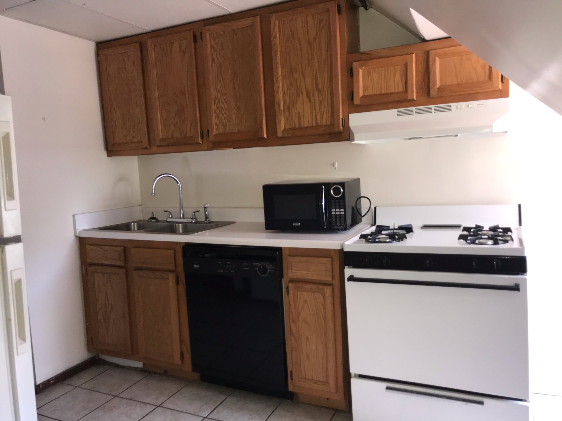 89 E Woodruff Ave. Unit C kitchen with oak cabinets, dishwasher, gas range, and full-size fridge